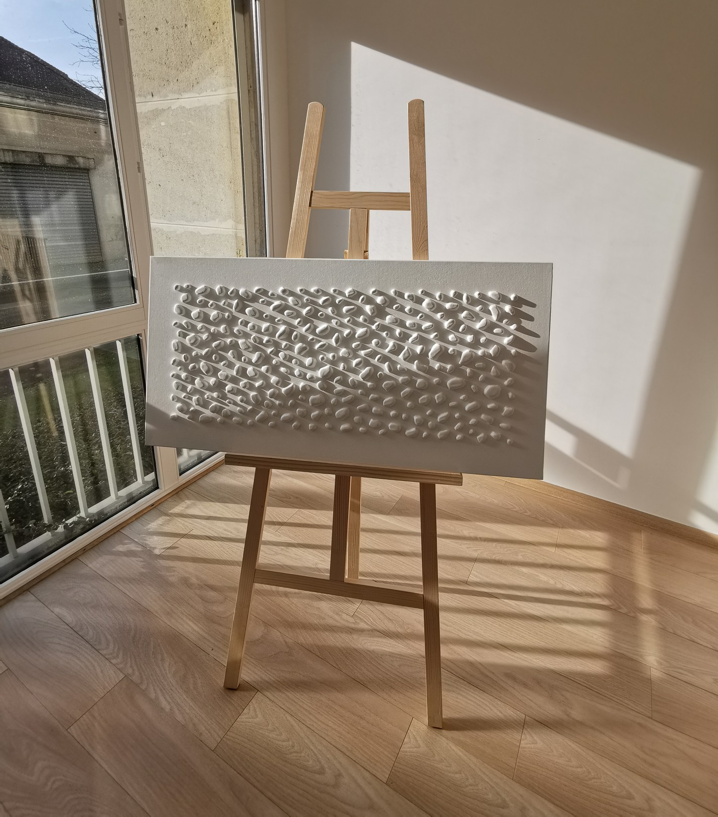 A white wall with a large white sculpture on it.