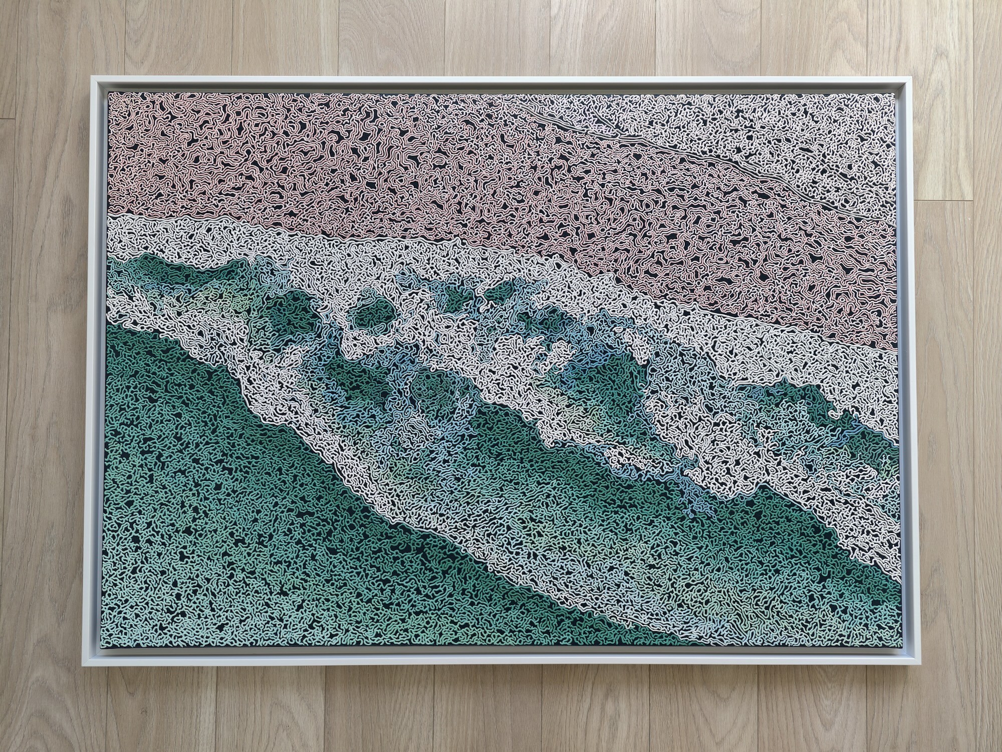 A rug on a wooden floor with a painting on it.