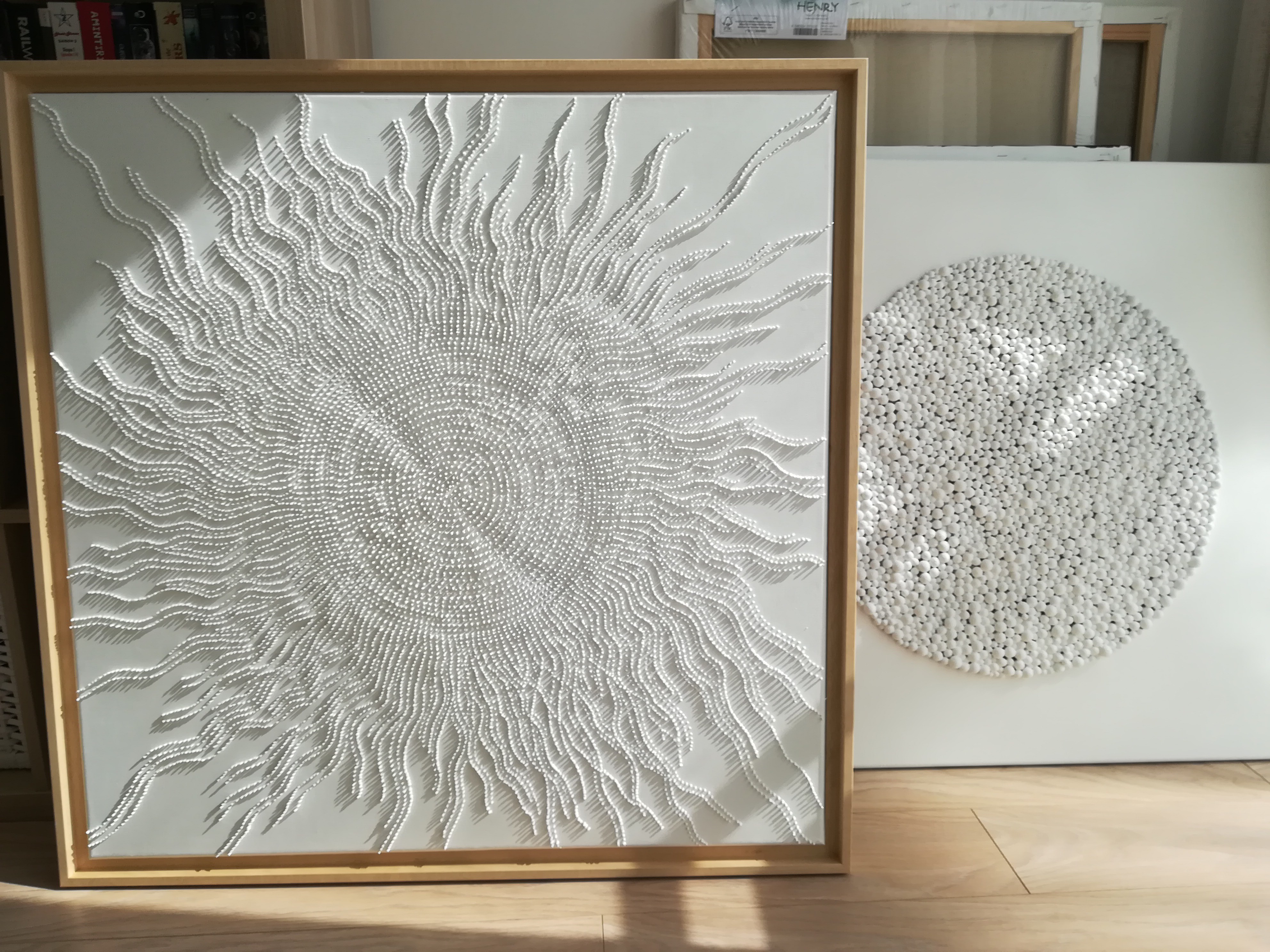 A large white painting on a white wall in a room.