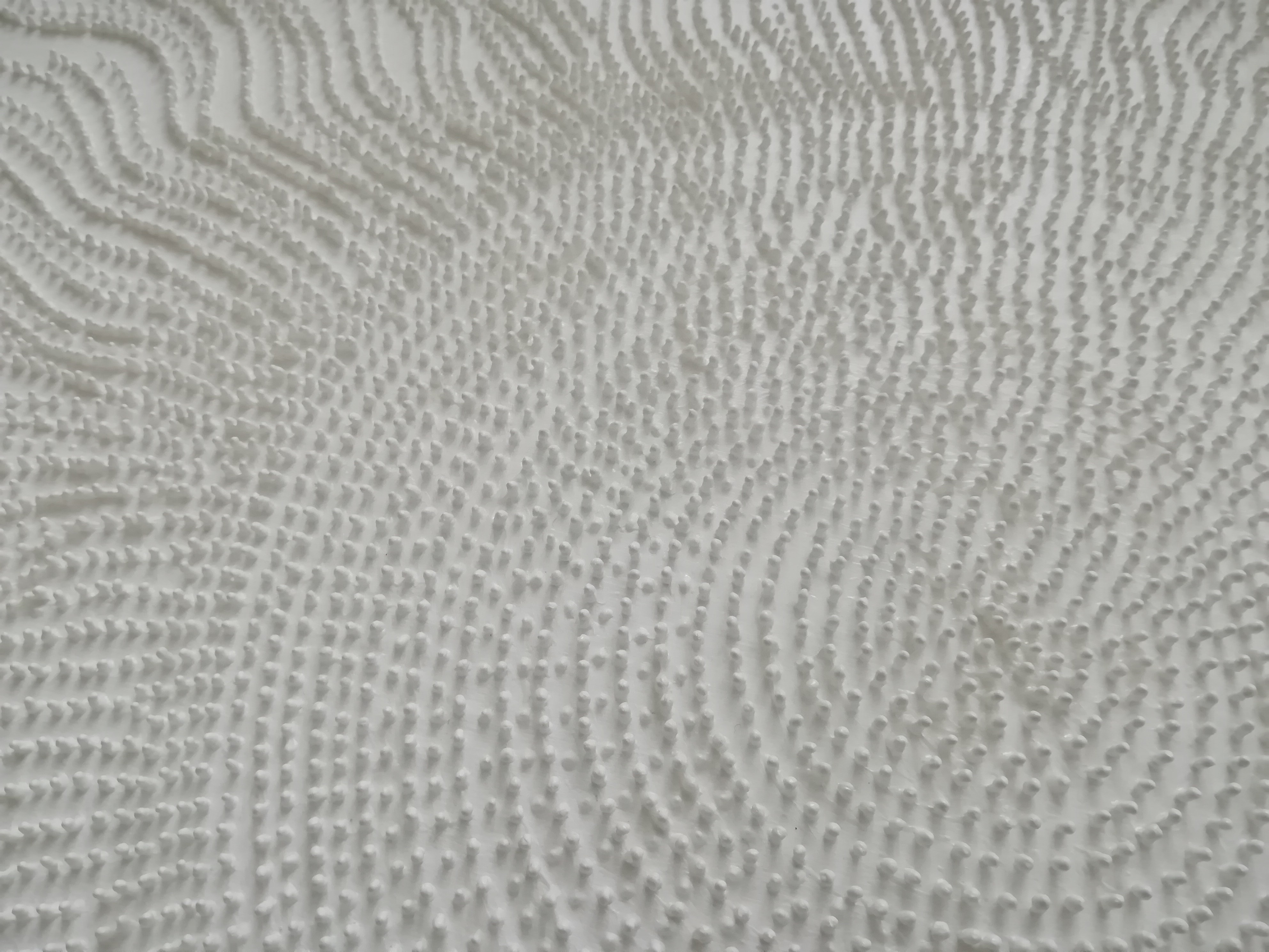 A large white painting on a white wall in a room.