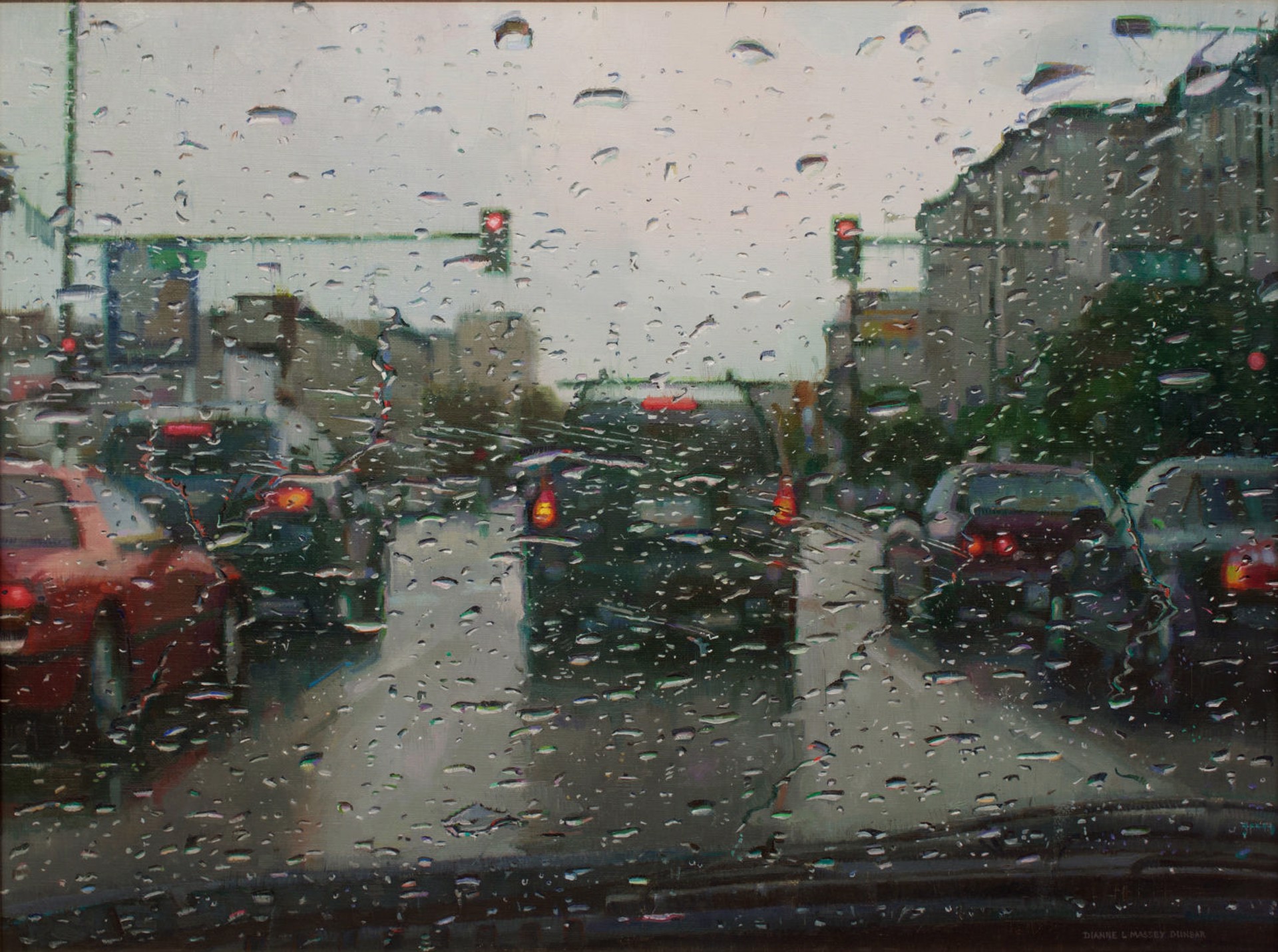 A rain-streaked view of traffic at an intersection.
