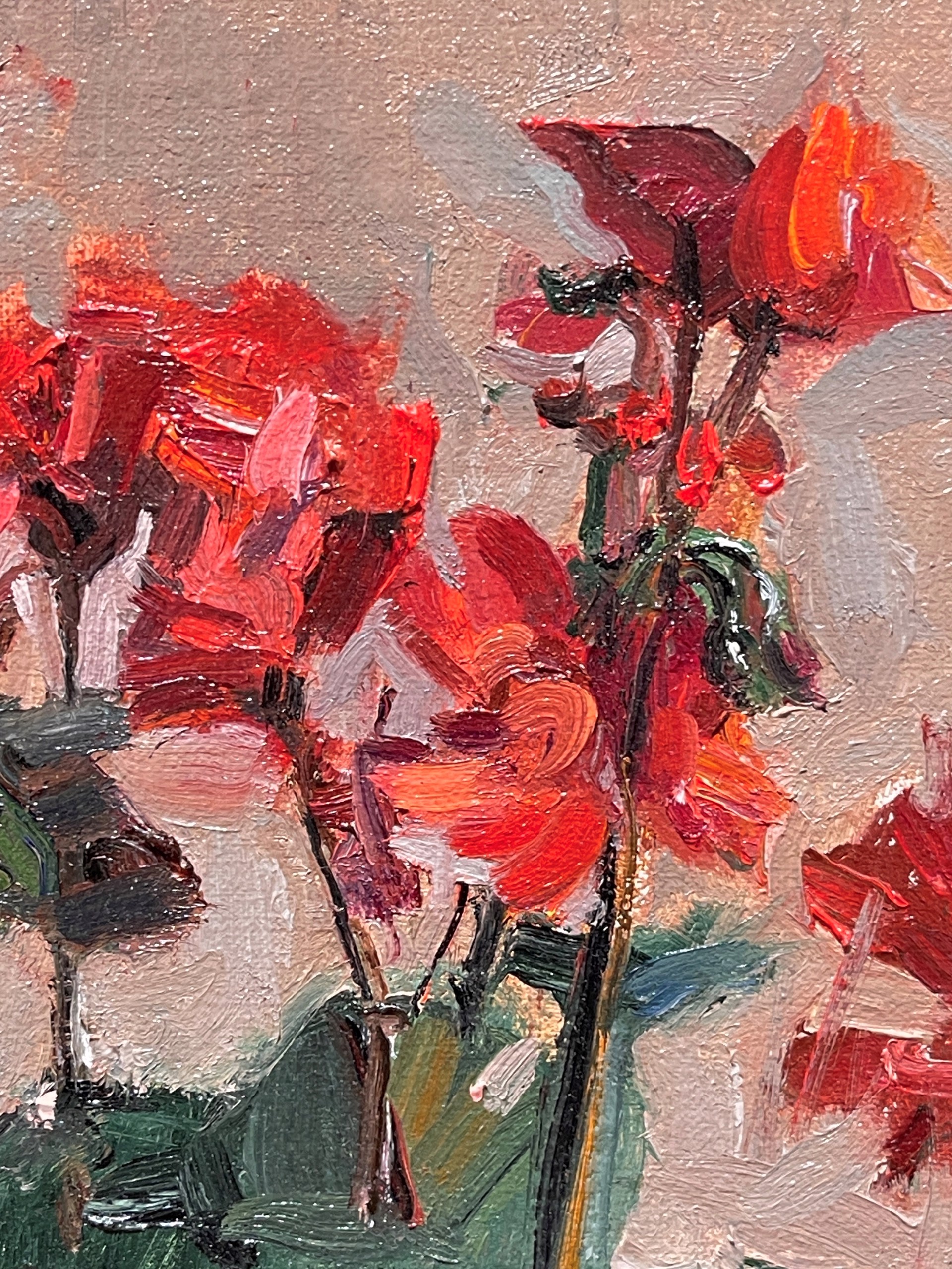 A painting of red geraniums in a black pot on a table.