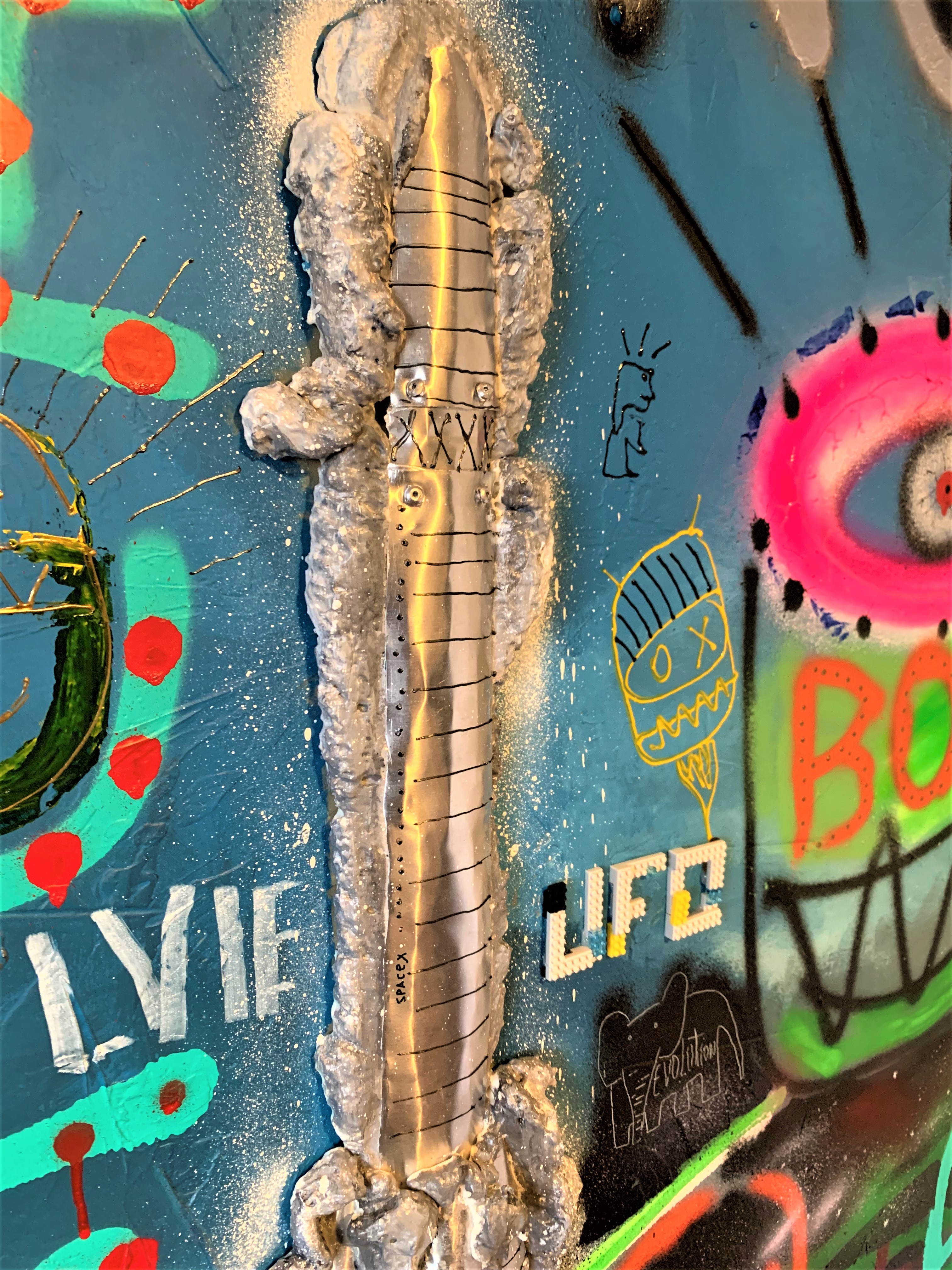 A painting of a rocket with graffiti on it.