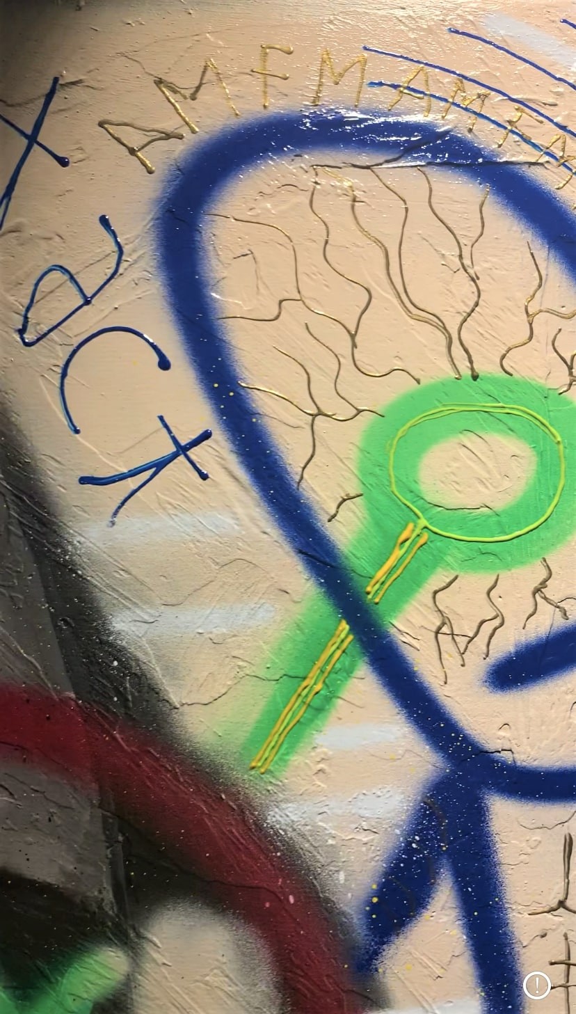 A close up of a wall with graffiti on it.