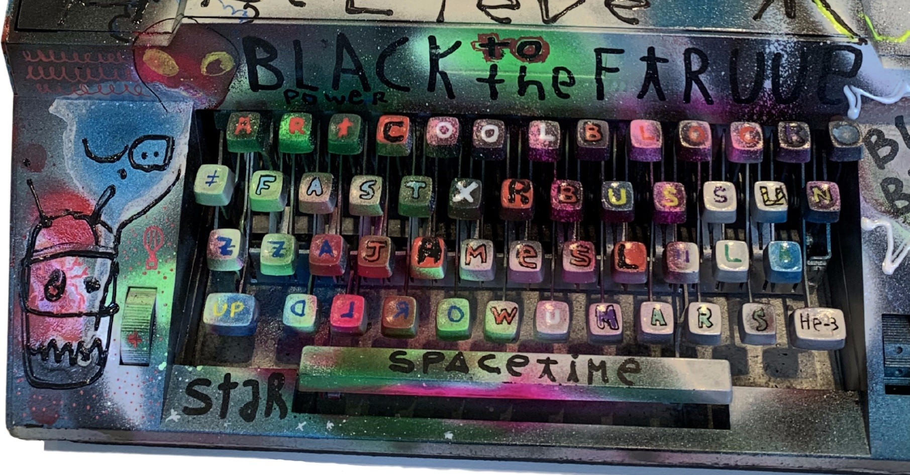 A close up of an old typewriter with graffiti on it.