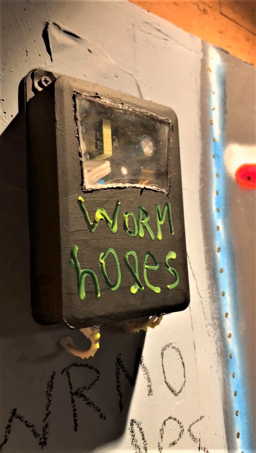 A sign that says worm holes on the side of a building.