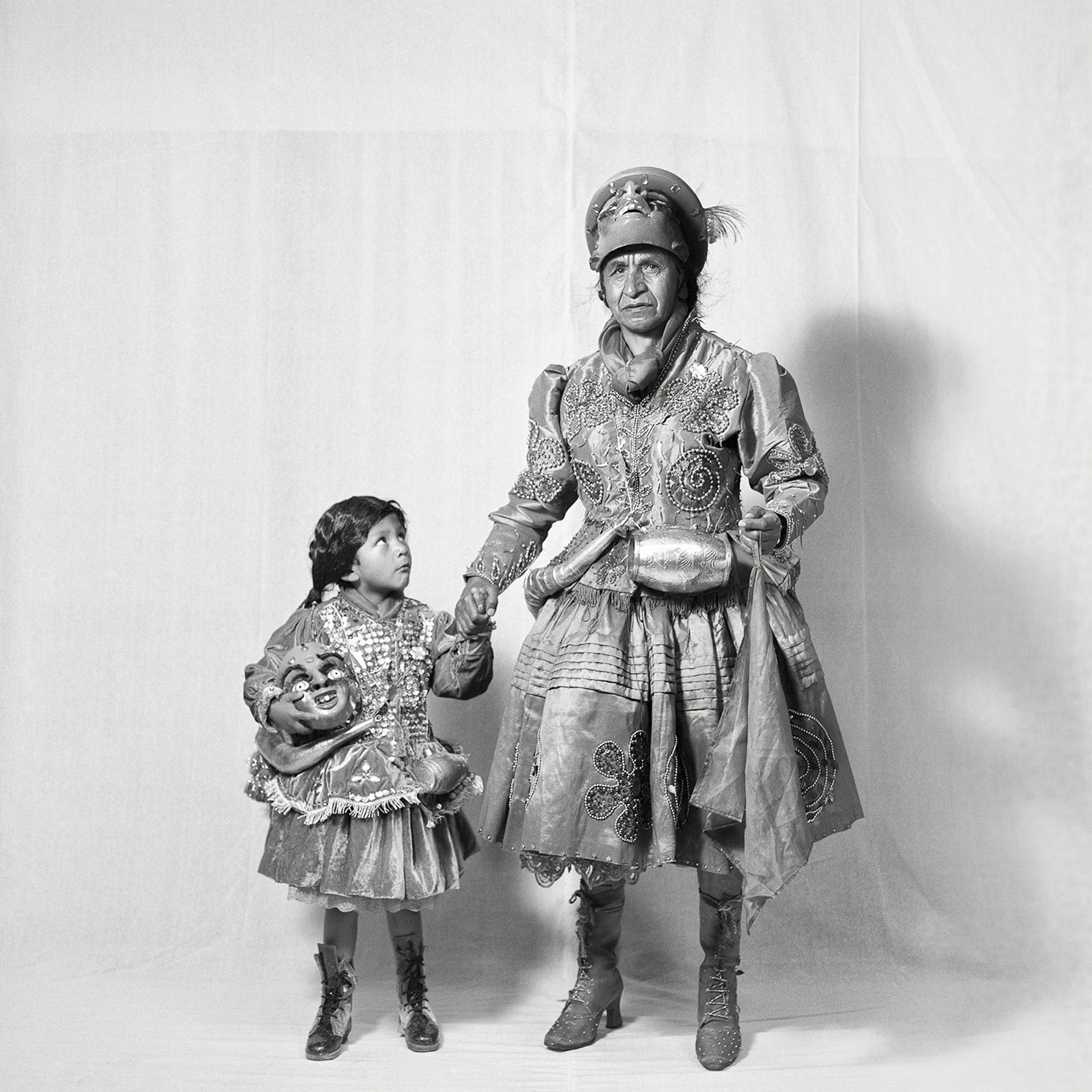 A man and a little girl dressed in costumes holding hands.