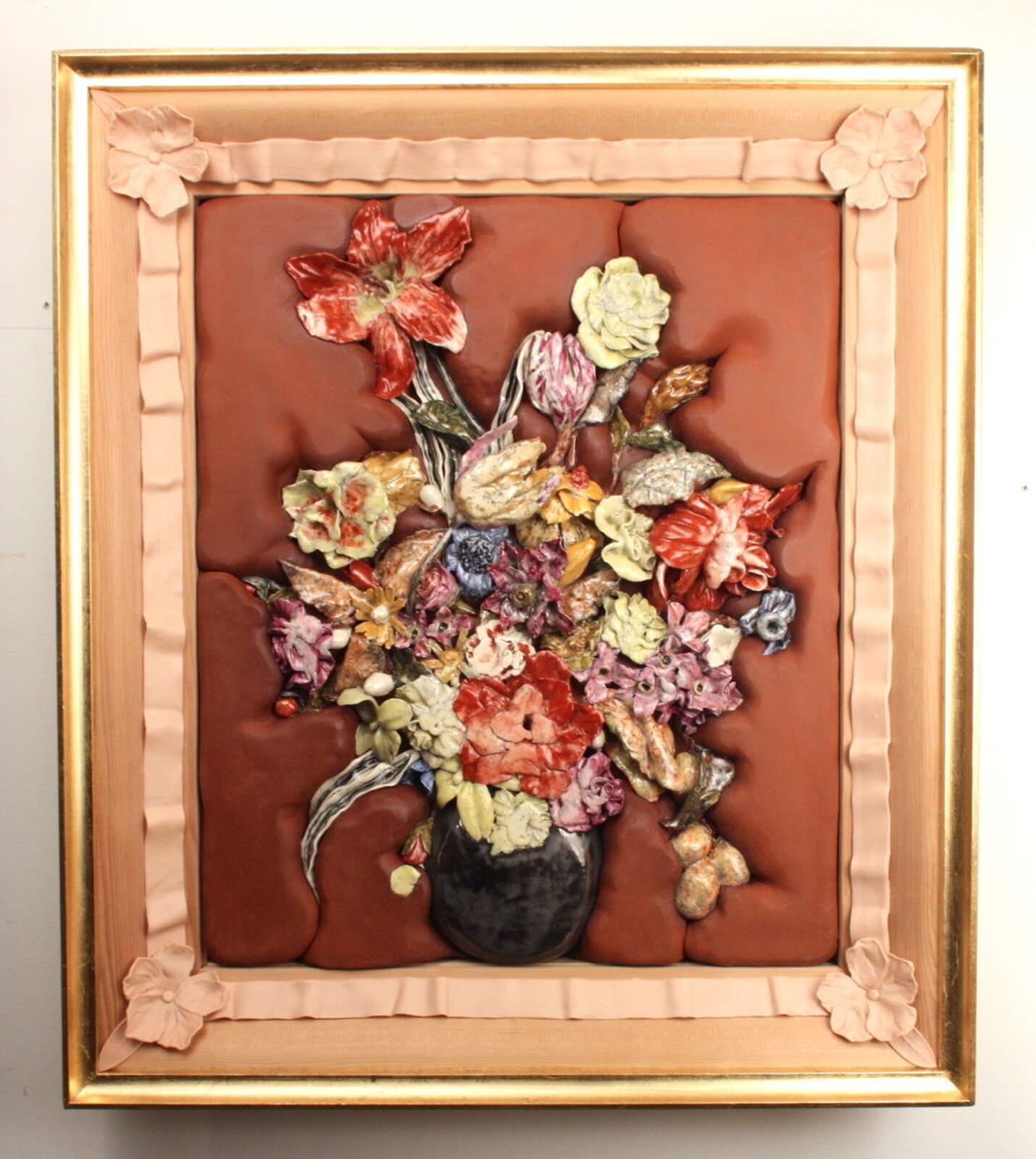 A richly textured still life featuring a bouquet of ceramic flowers in a dark vase against a tufted brown background.