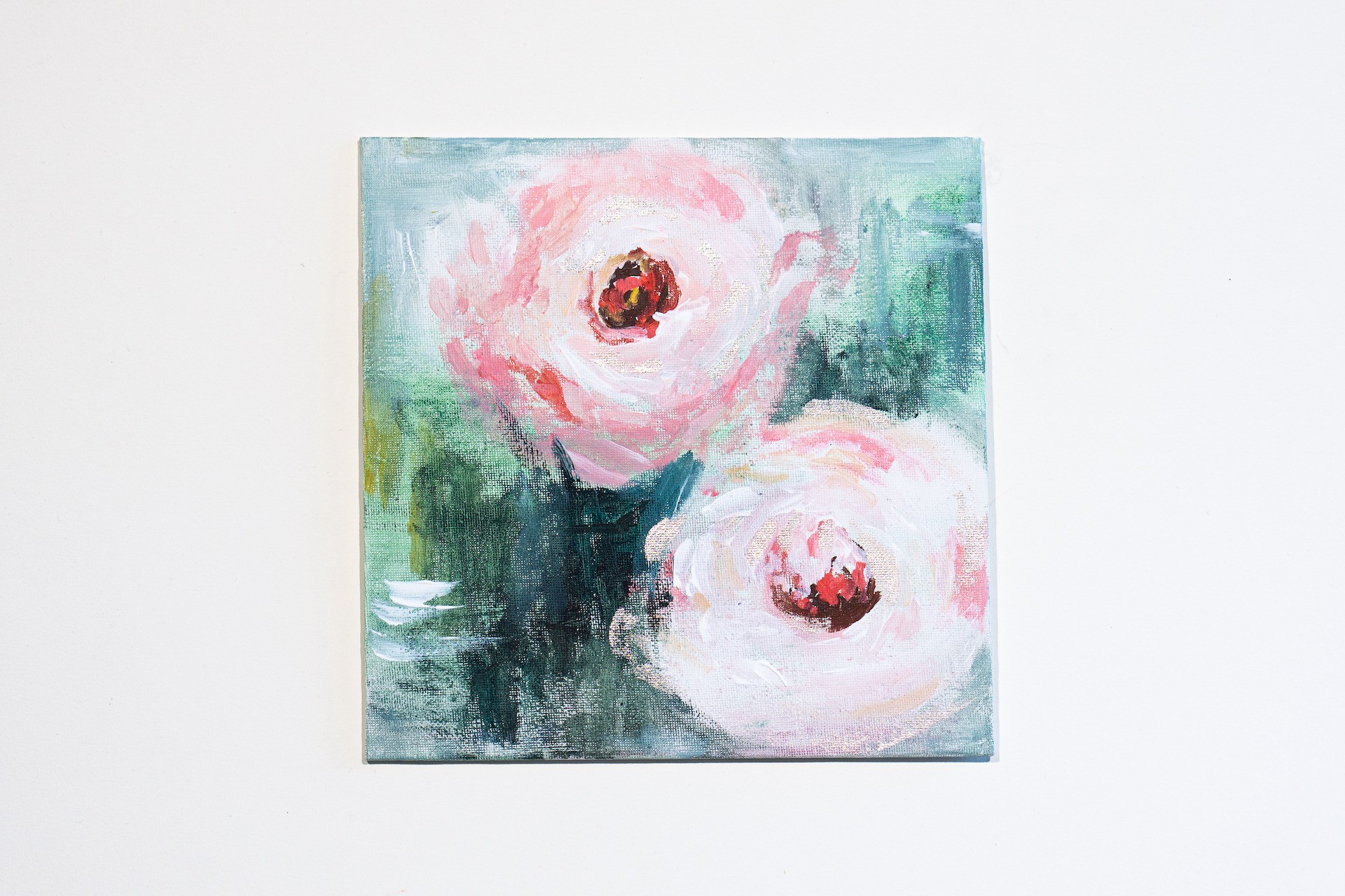A painting of two pink flowers on a white wall.