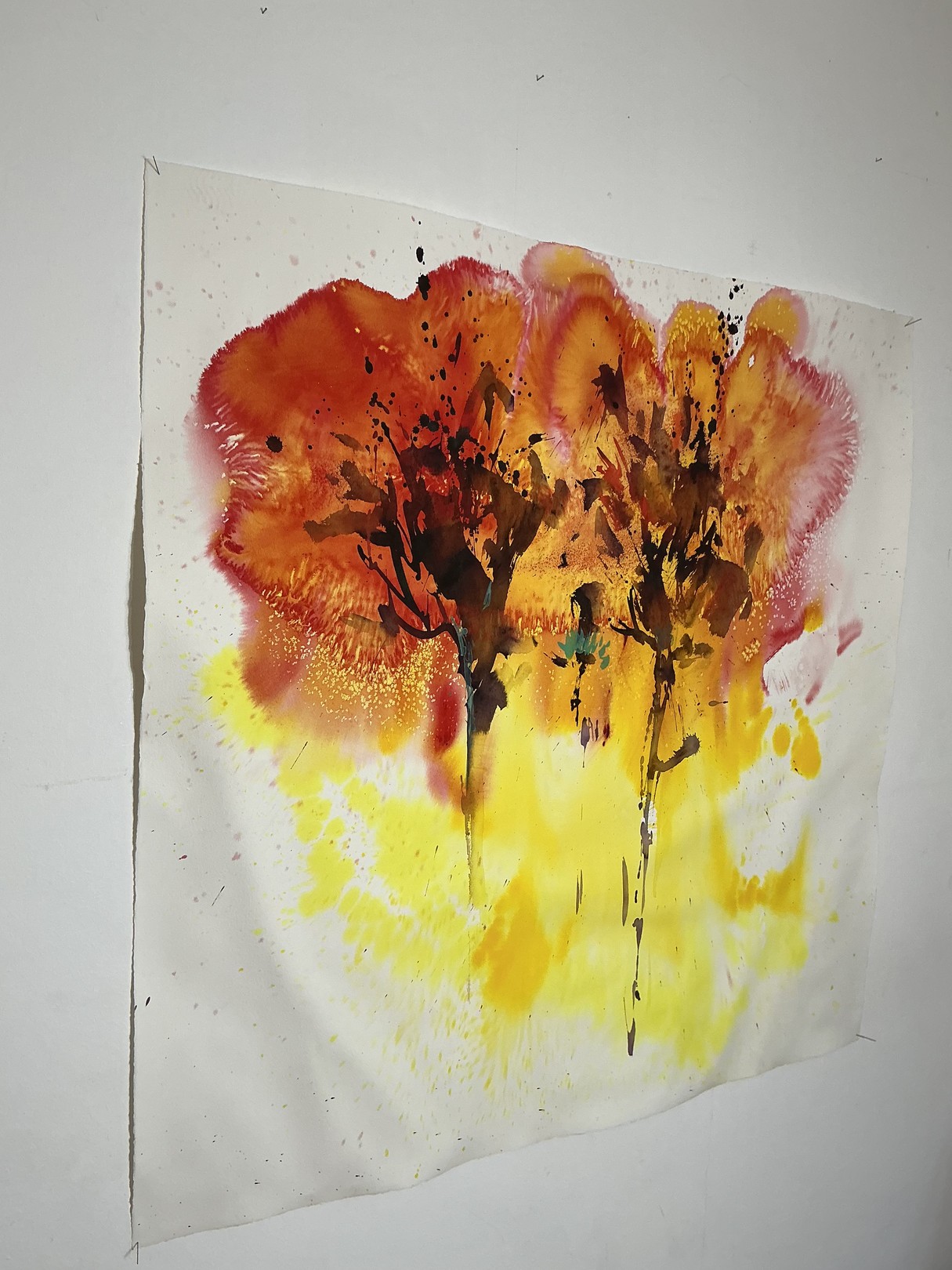 A watercolor painting of two trees on a white wall.