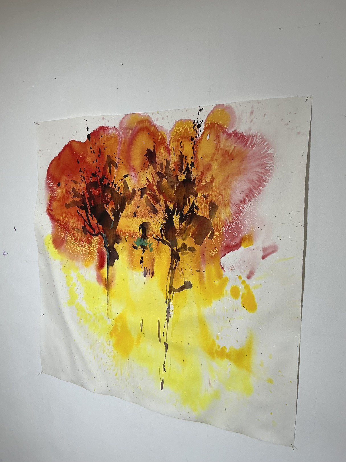 A watercolor painting of two trees on a white wall.