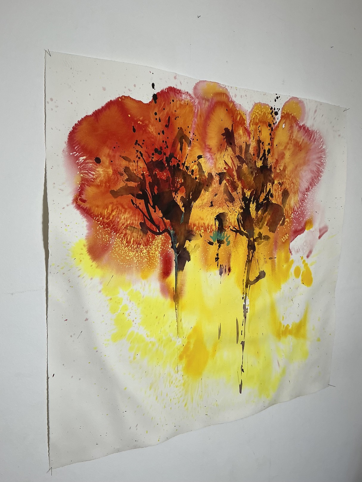 A watercolor painting of two trees on a white wall.