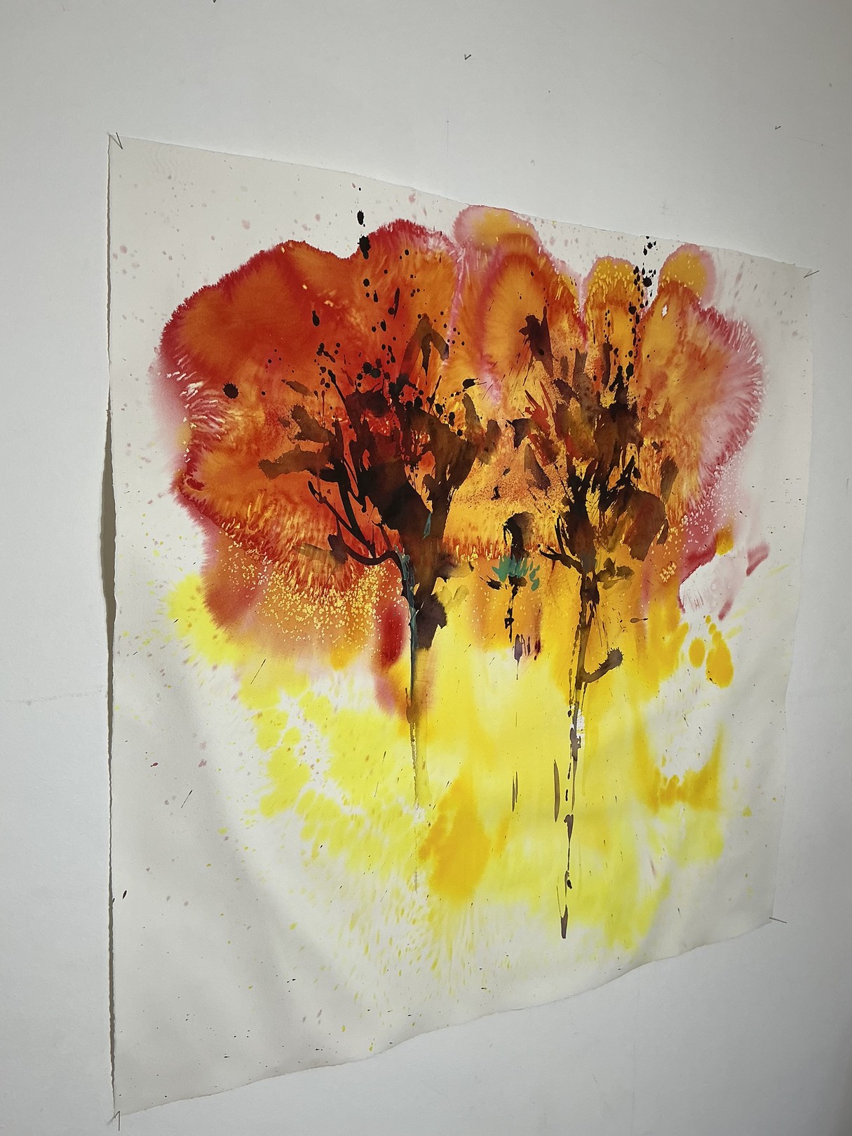 A watercolor painting of two trees on a white wall.