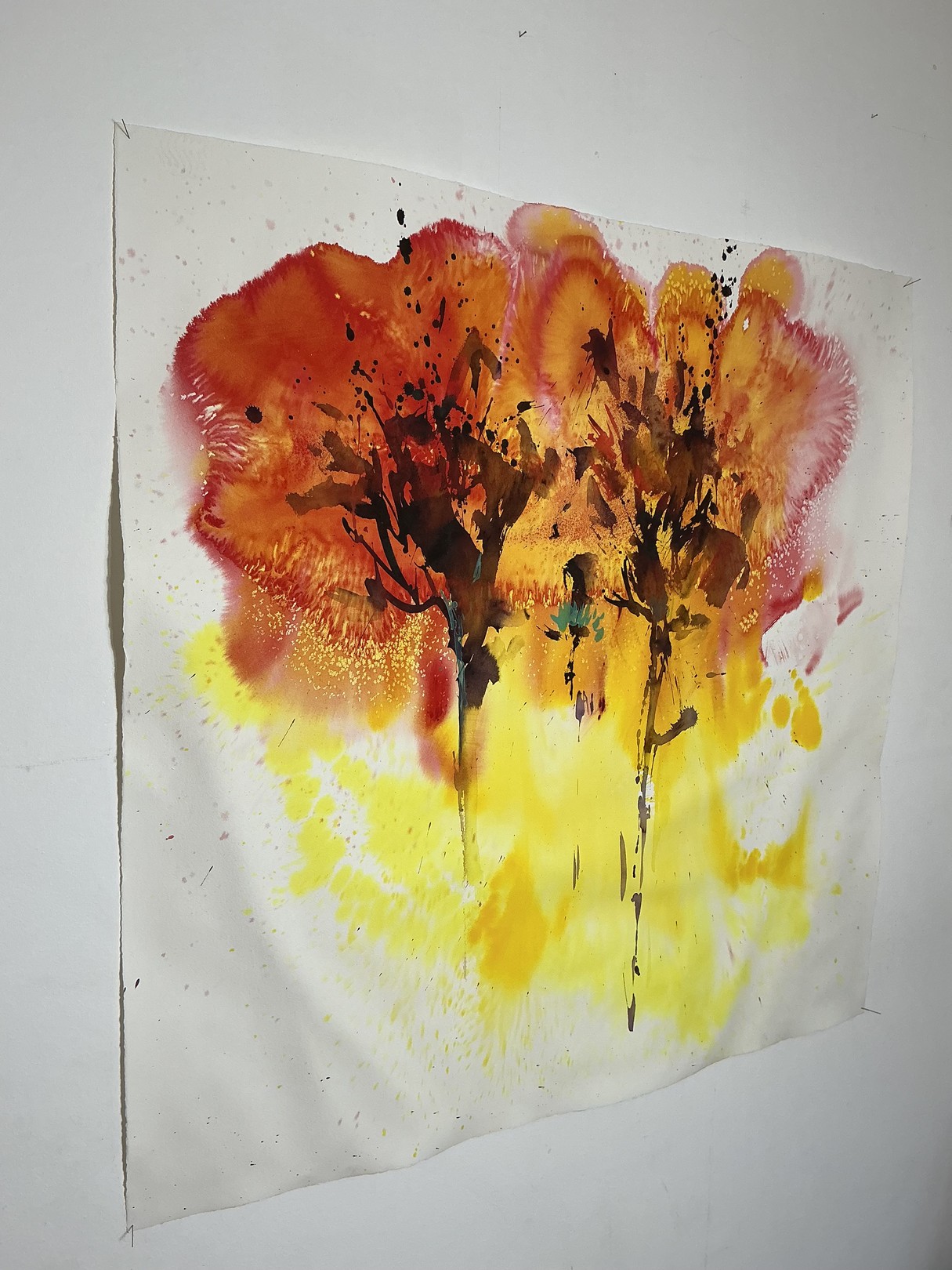 A watercolor painting of two trees on a white wall.