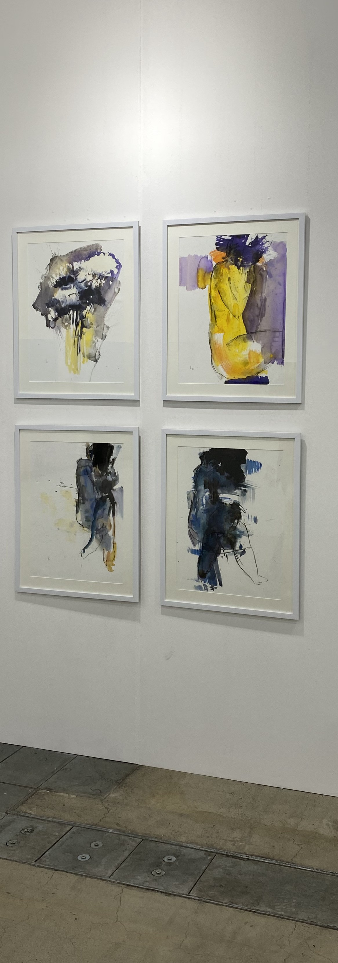 Three paintings hanging on a wall in a room.