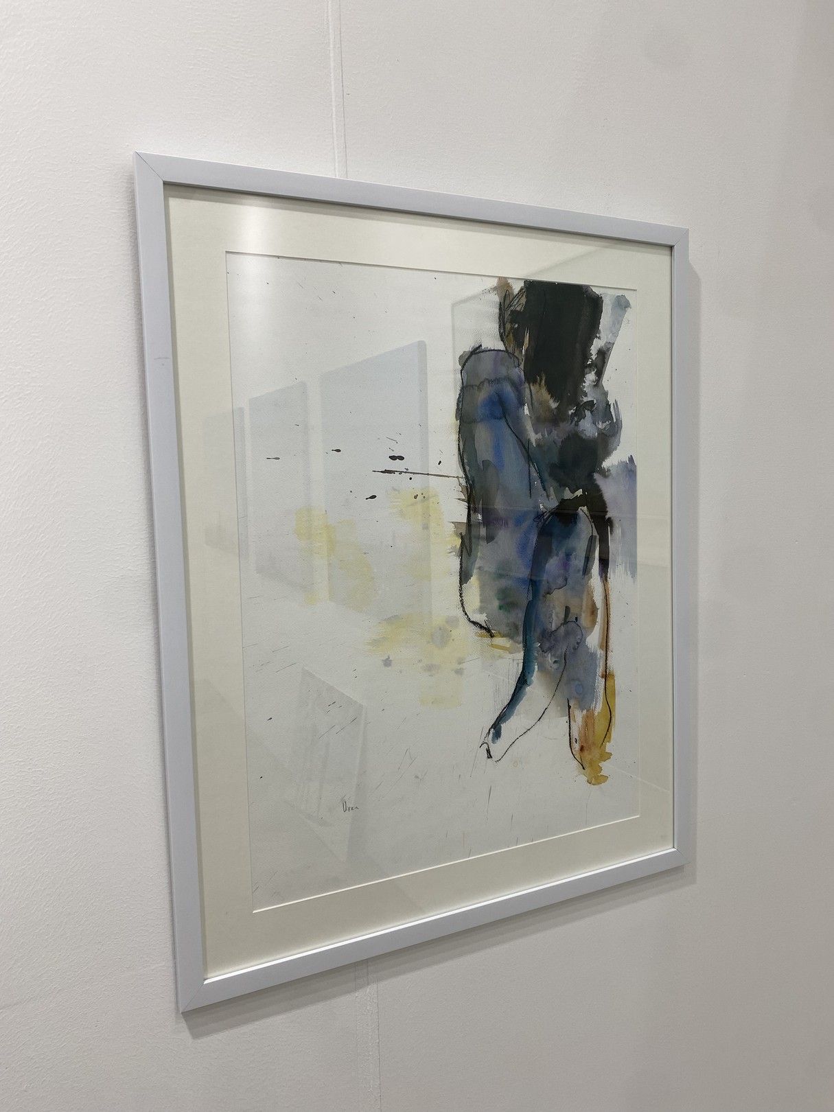 Three paintings hanging on a wall in a room.