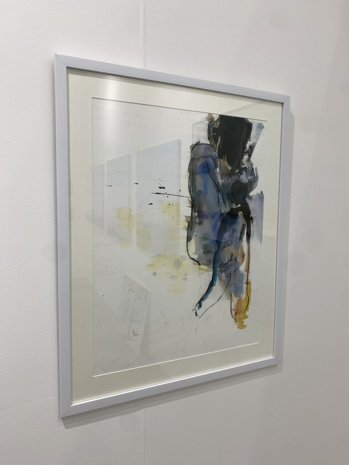 Three paintings hanging on a wall in a room.