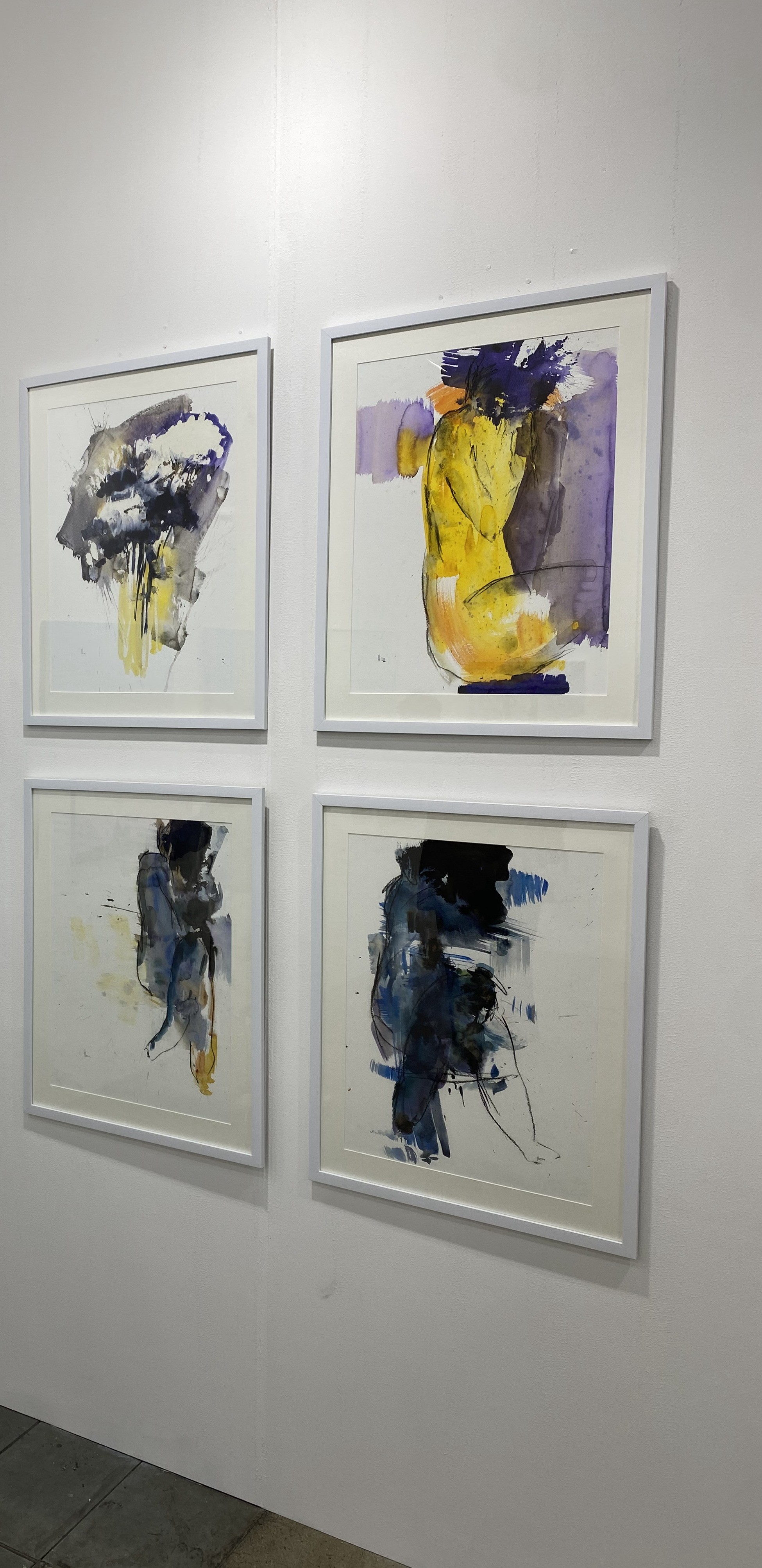 Three paintings hanging on a wall in a room.