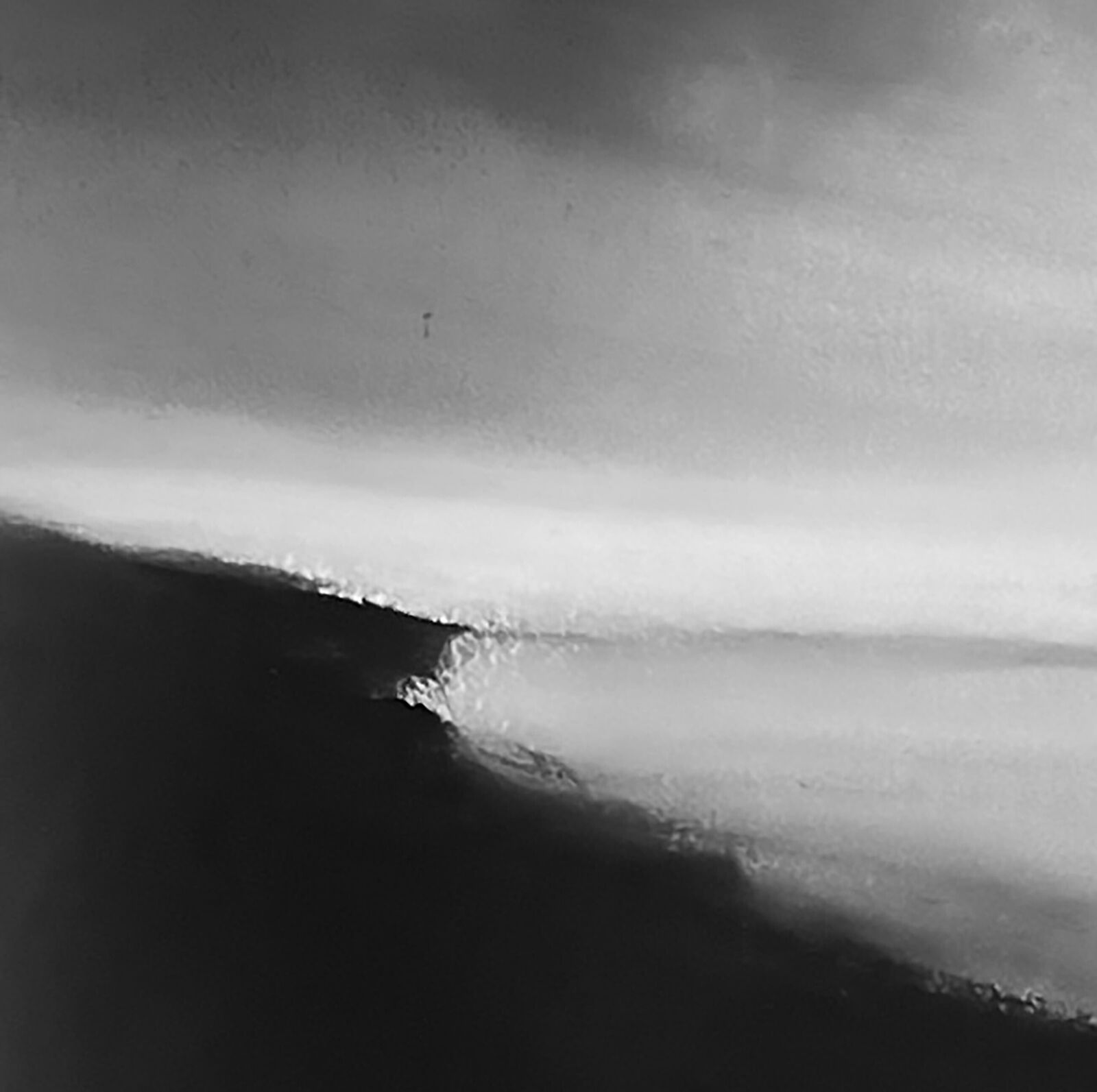 A monochromatic seascape painting depicting a dark, jagged coastline under a vast, cloudy sky.