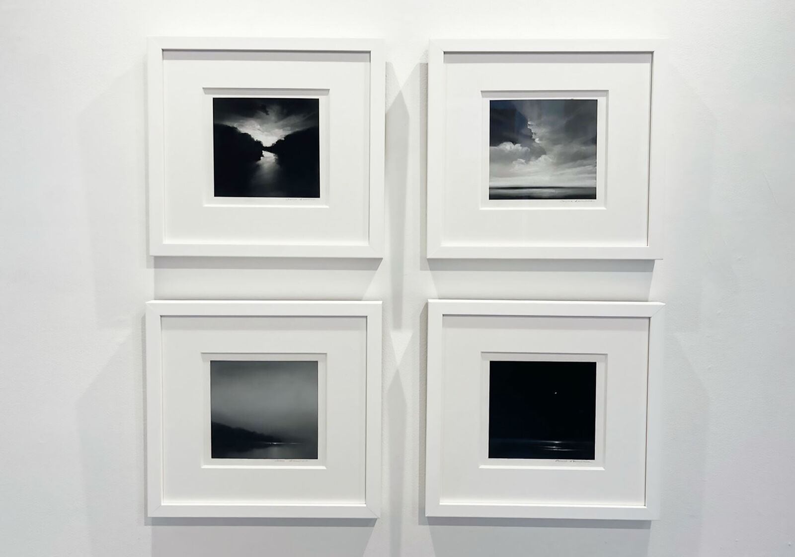 A monochromatic landscape painting depicting a river reflecting a bright sky between dark silhouettes.