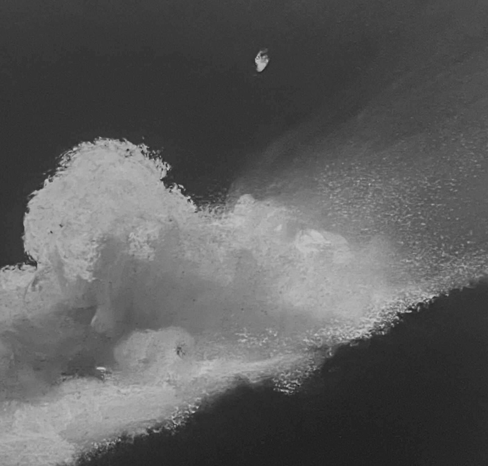 A dramatic monochrome seascape featuring a massive, textured cloud formation looming over a dark ocean.
