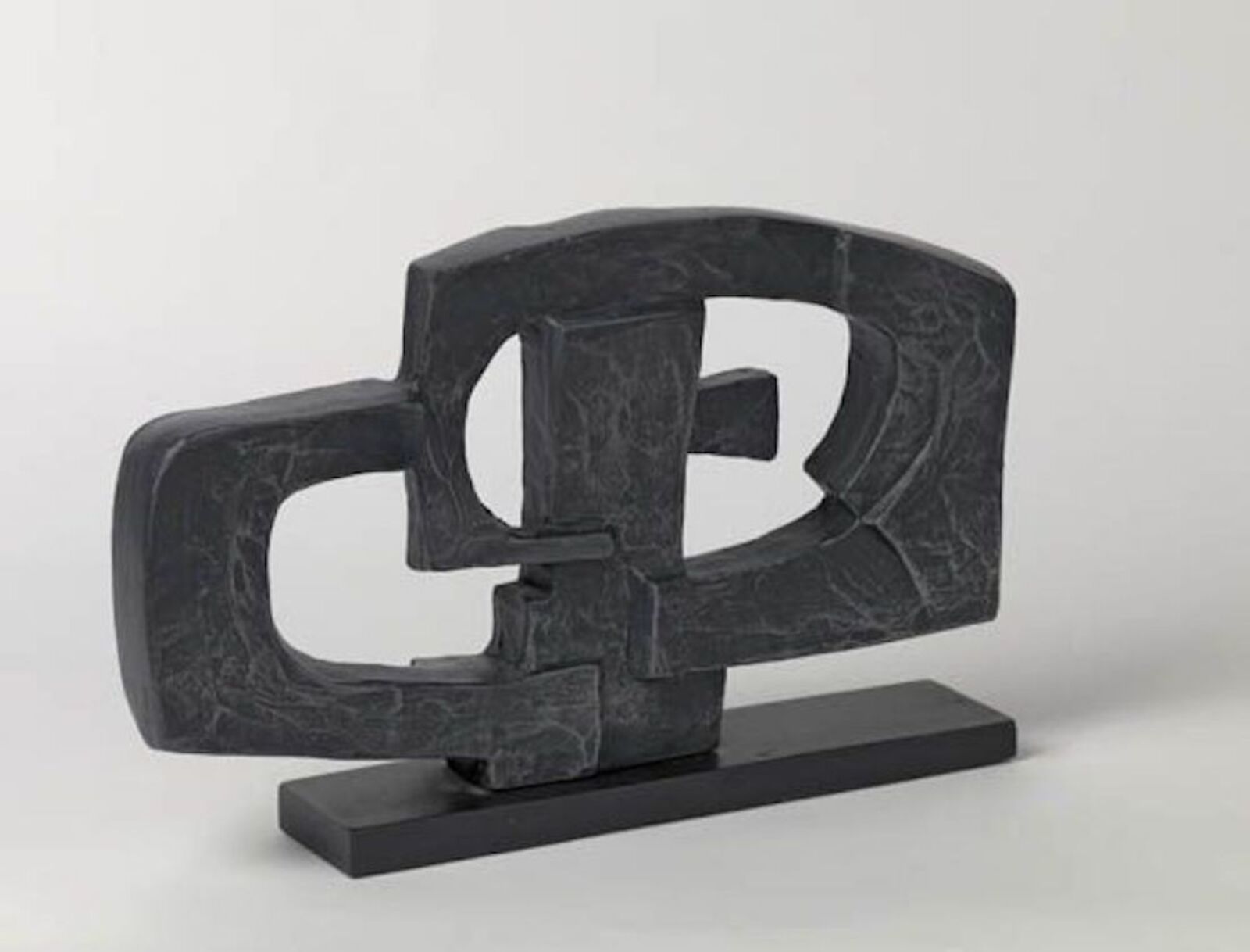 A black sculpture of a letter B on a black base.