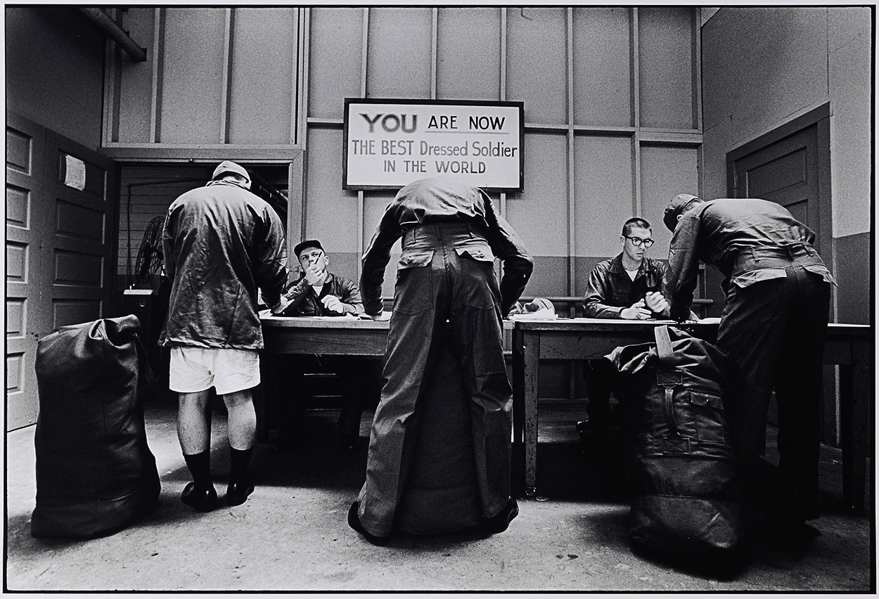 A group of men standing around a table in a room.