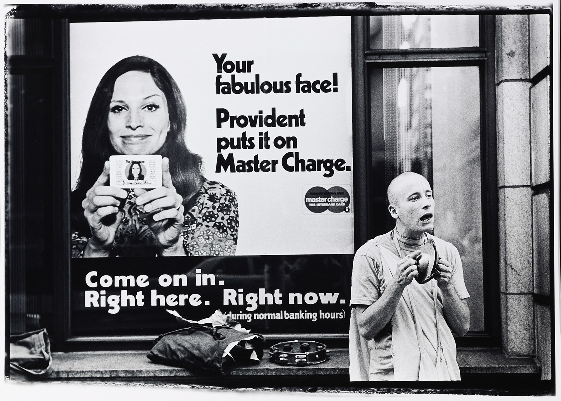 A man standing in front of a window holding a cell phone.