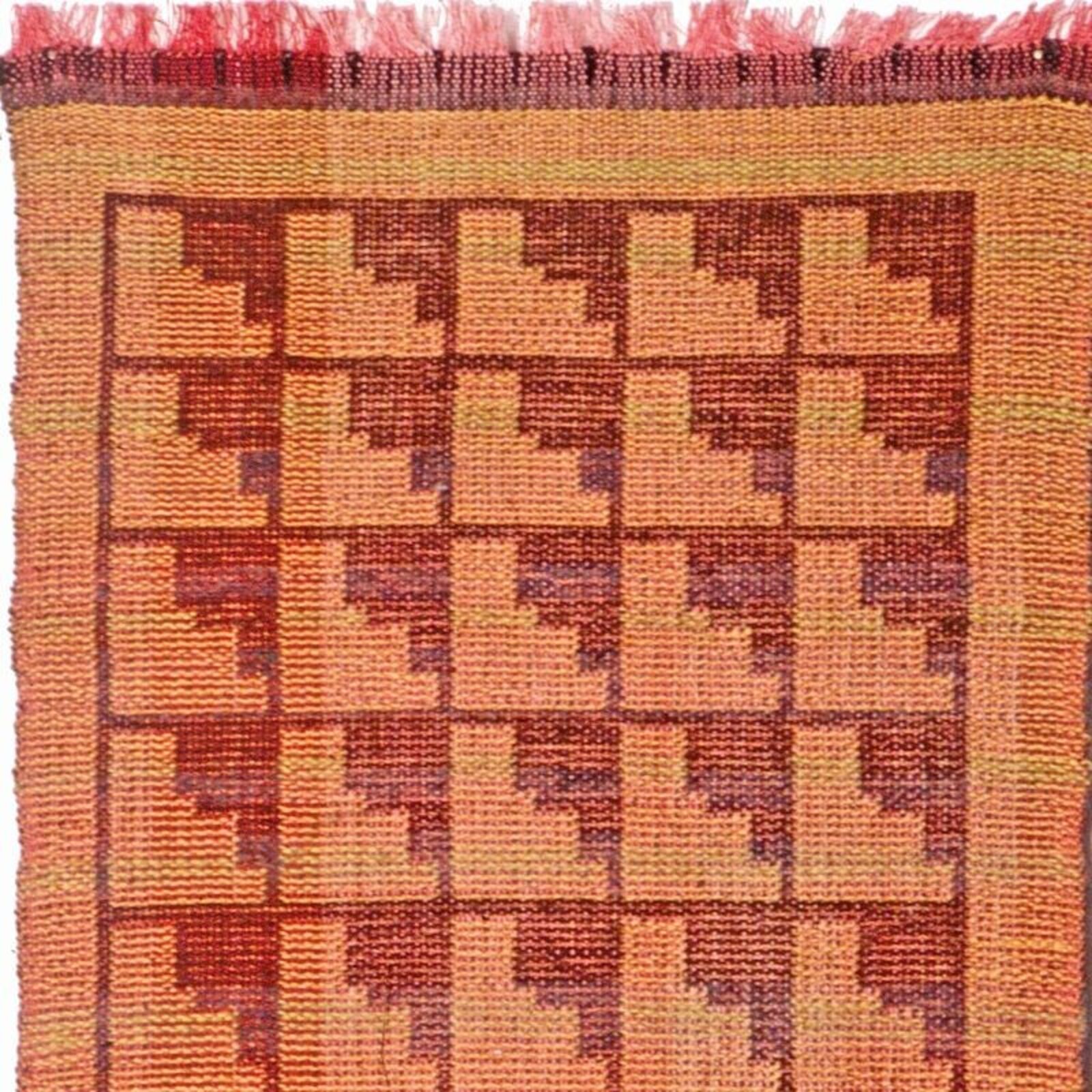 A framed woven textile featuring geometric patterns in earthy tones.