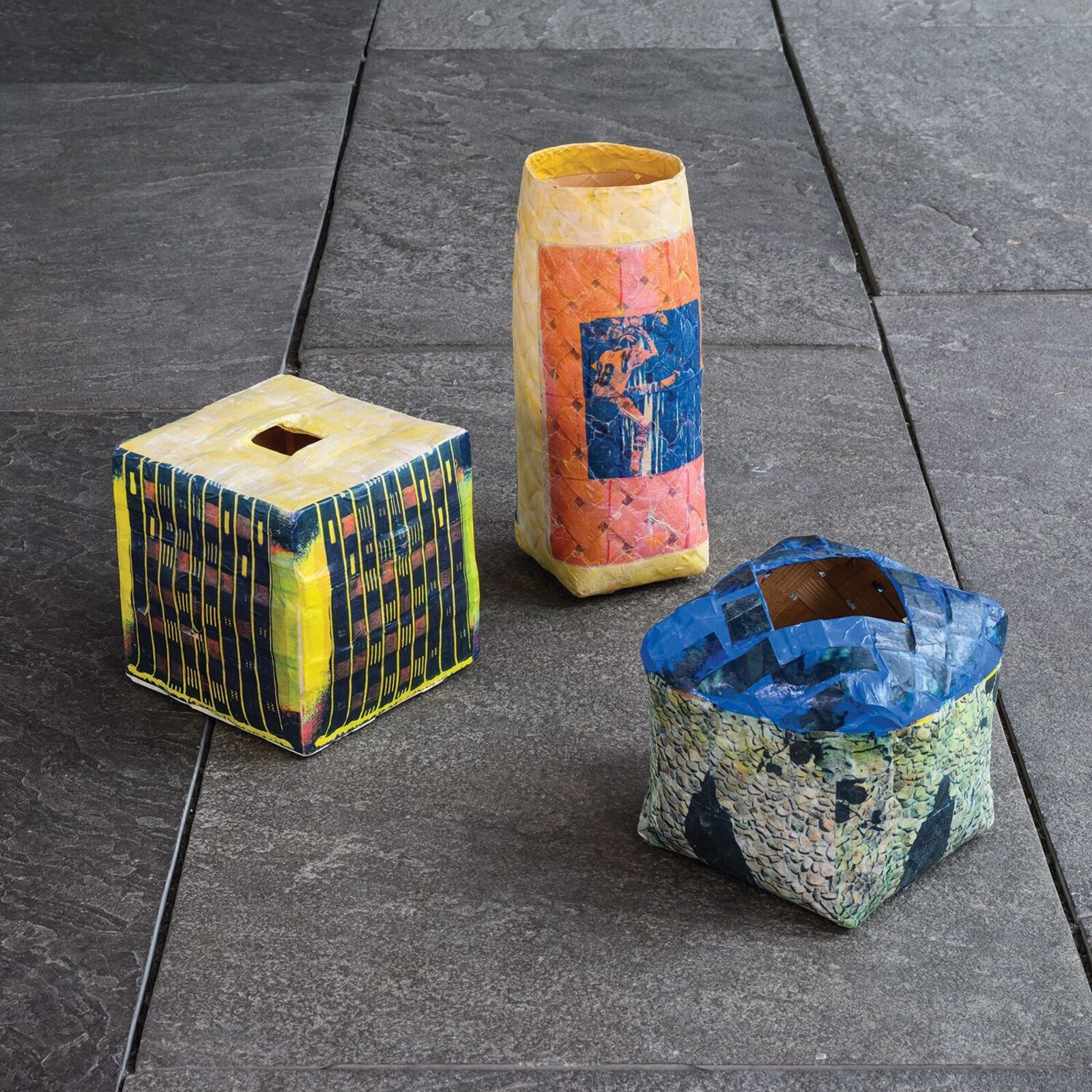 A colorful, cube-shaped box with a geometric pattern and a square opening on top.