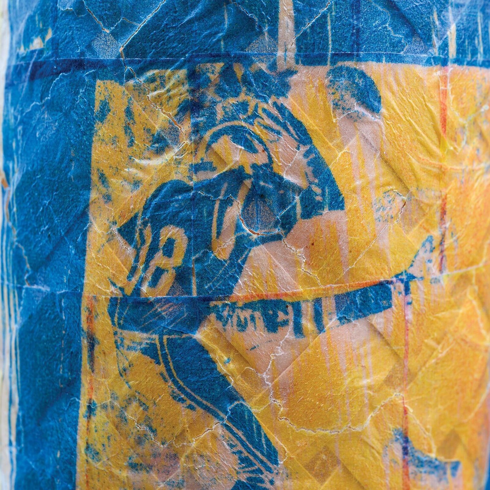 A textured, multi-colored vase featuring a blue square print of a figure.