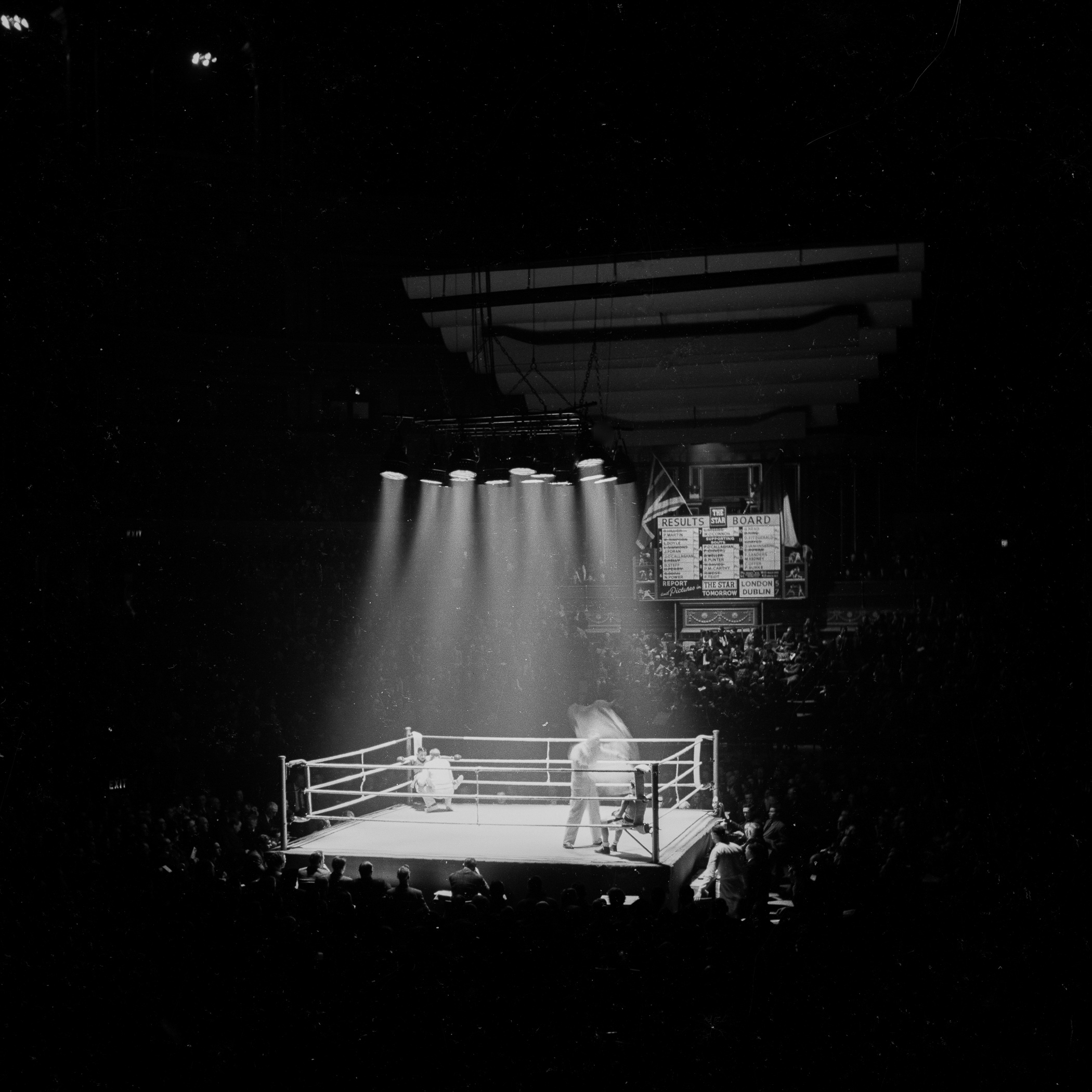 A boxing ring with a crowd of people watching it.