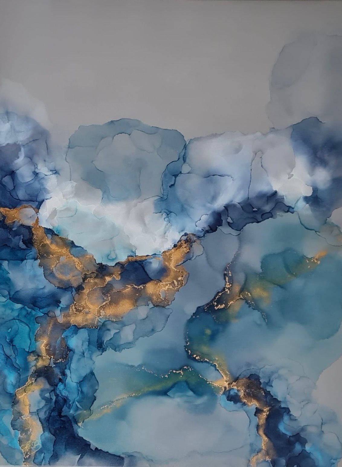 A fluid abstract composition featuring flowing blue and gold ink on a neutral background.