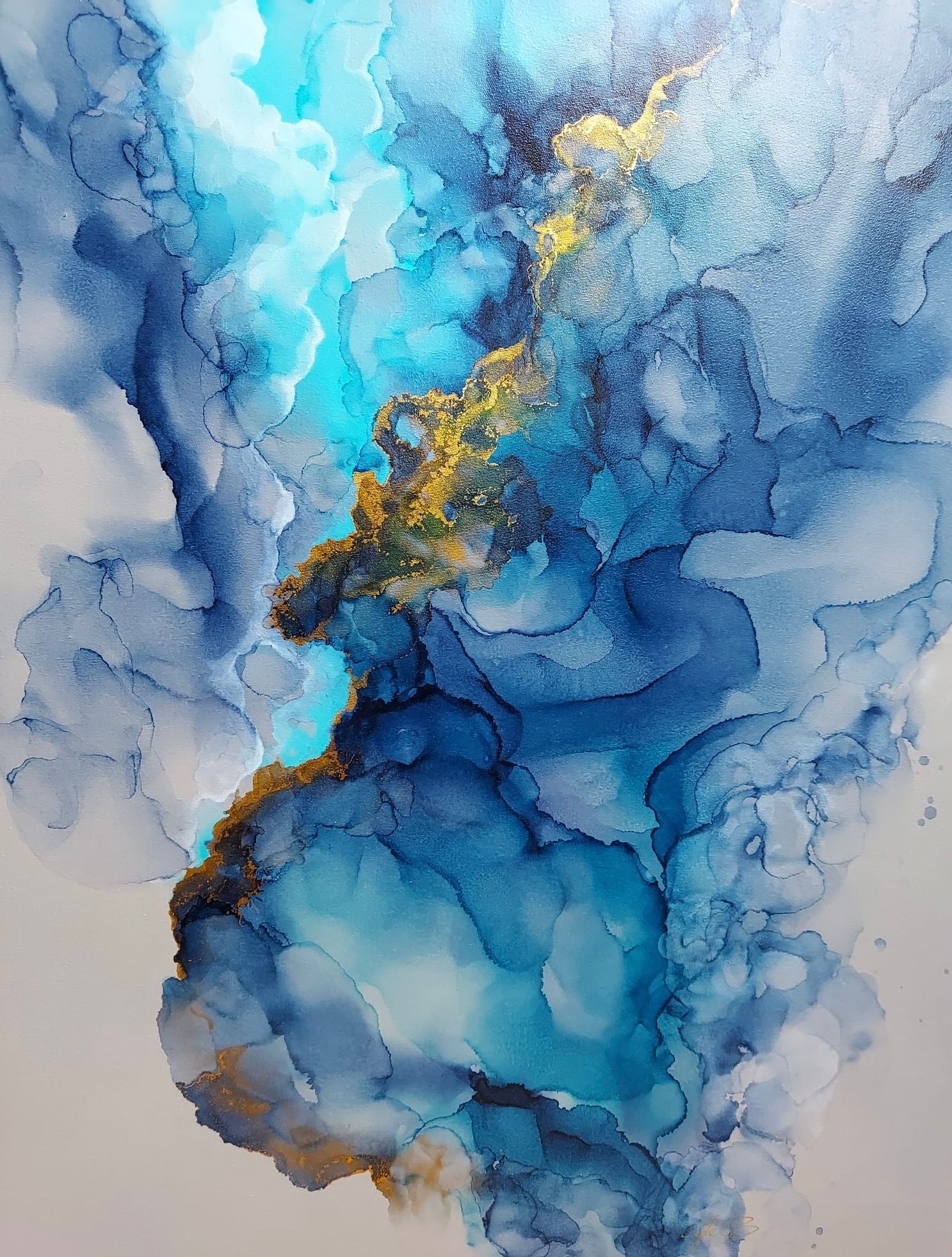 An abstract fluid painting featuring a central gold vein amidst swirling blue and white clouds.