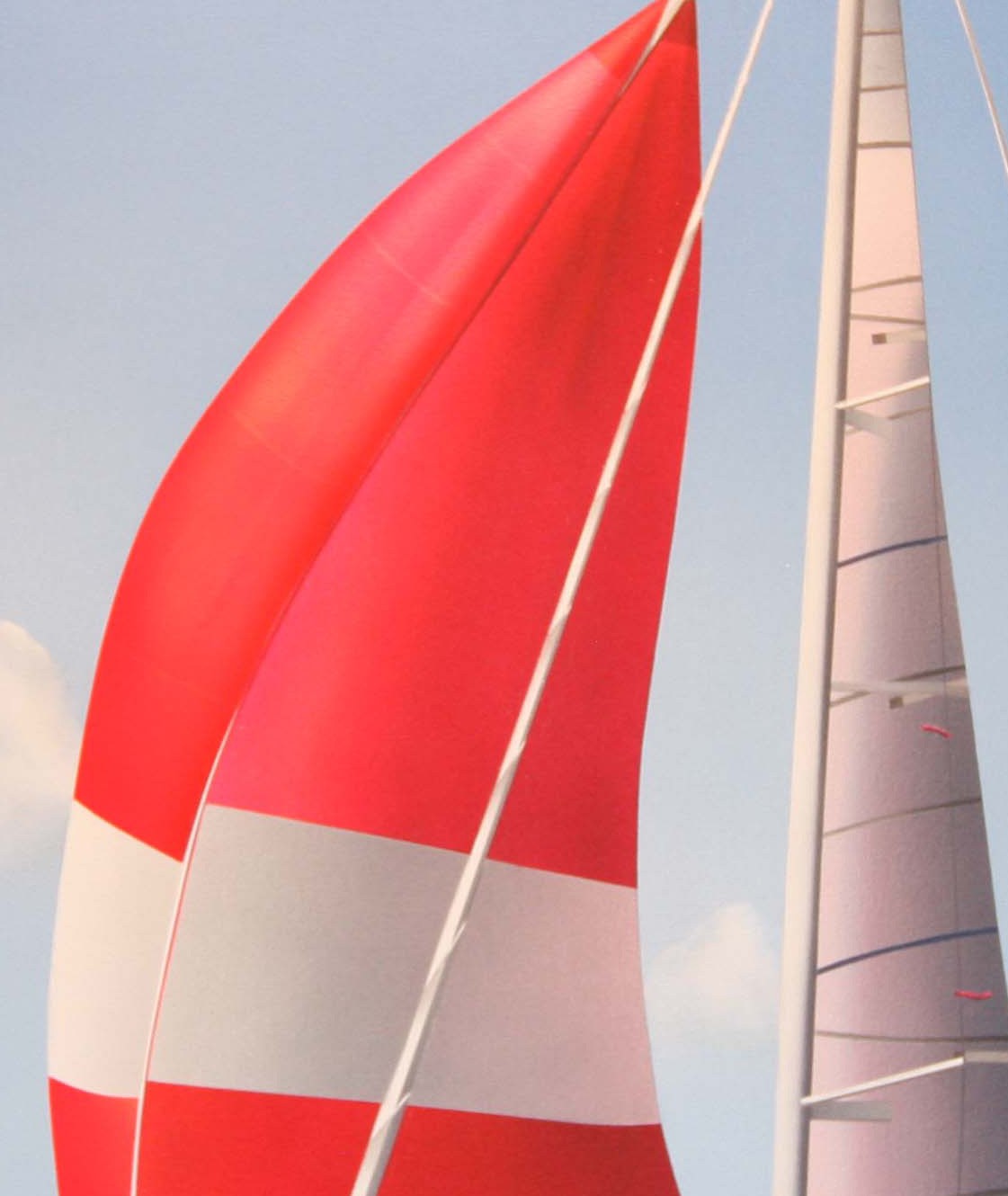 A red and white sailboat with a blue sky in the background.