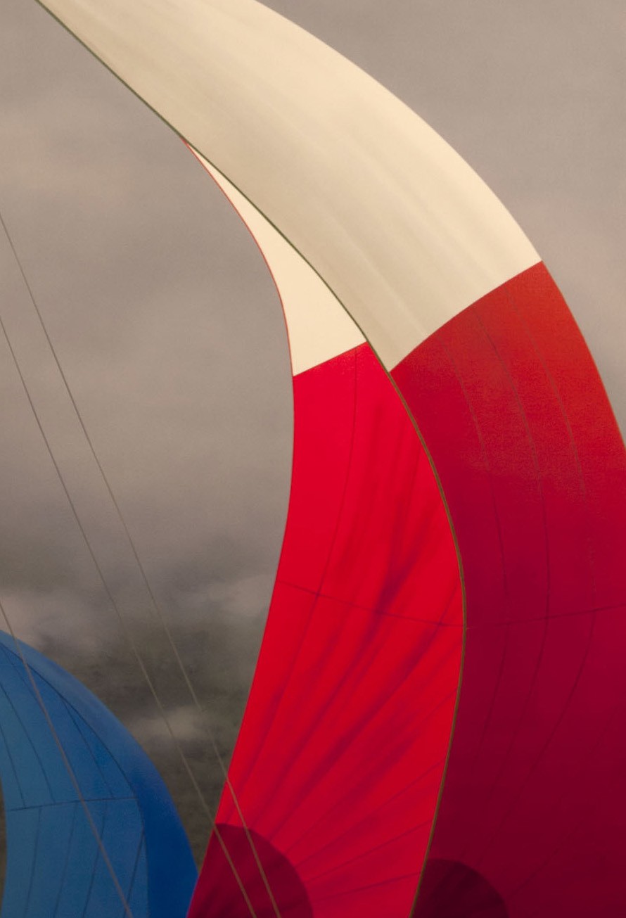 A close up of a red, white and blue hot air balloon in the sky.