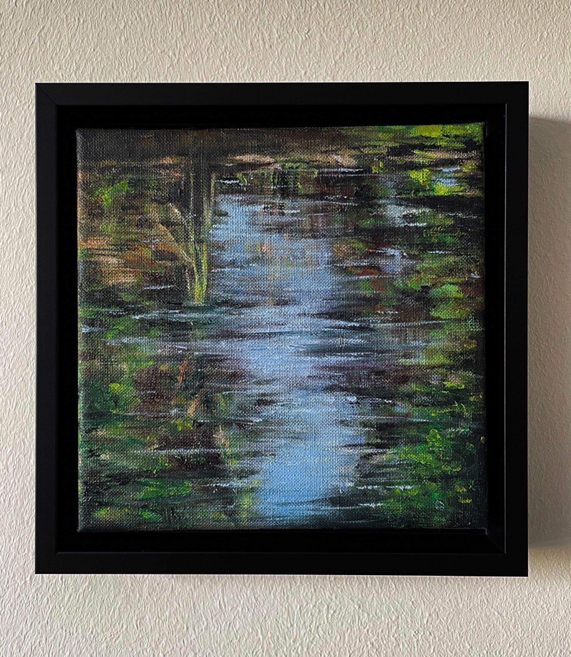 A textured painting of a narrow stream reflecting light, surrounded by dense foliage.