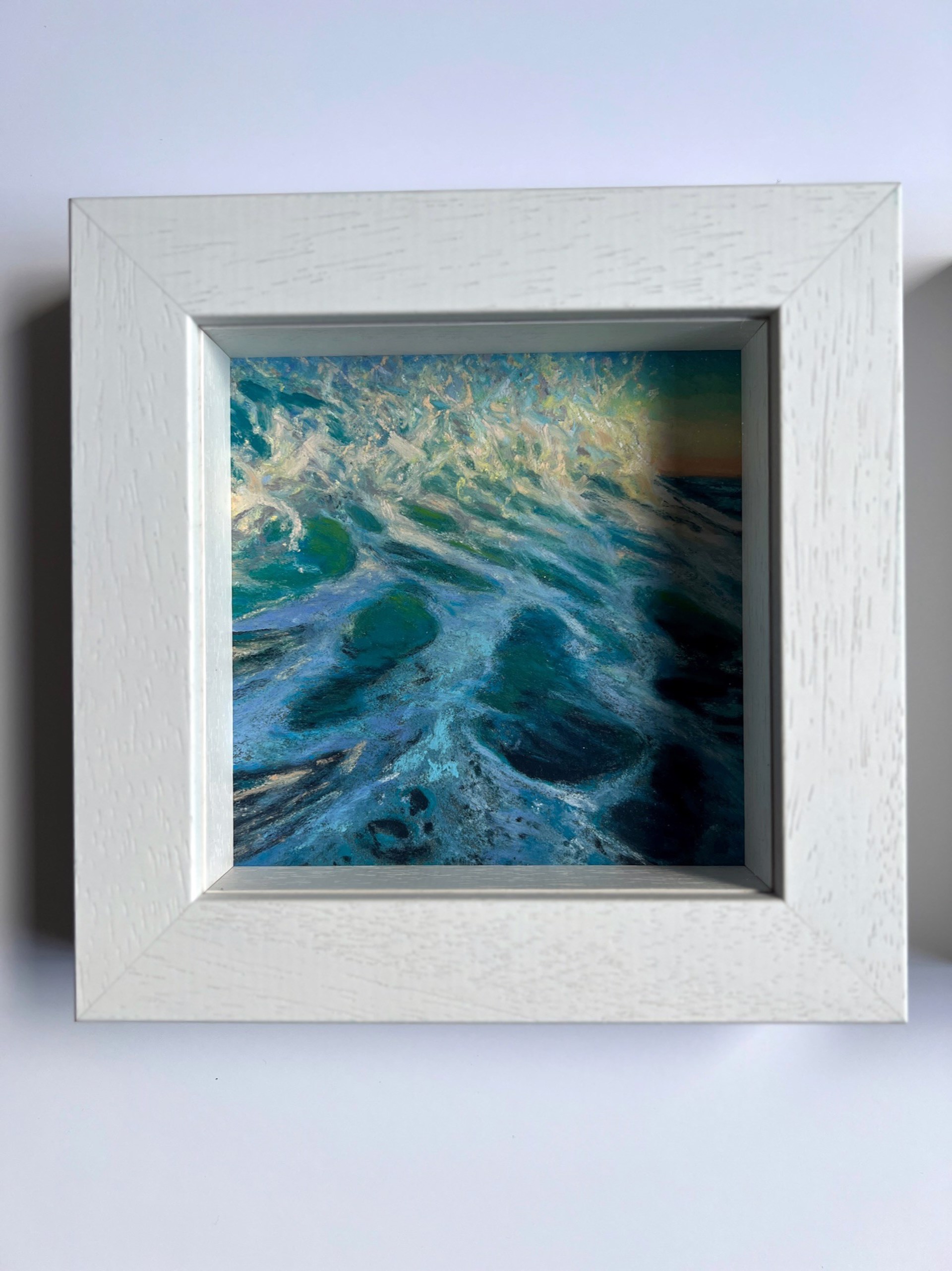 A painting of a wave crashing on the beach at sunset.