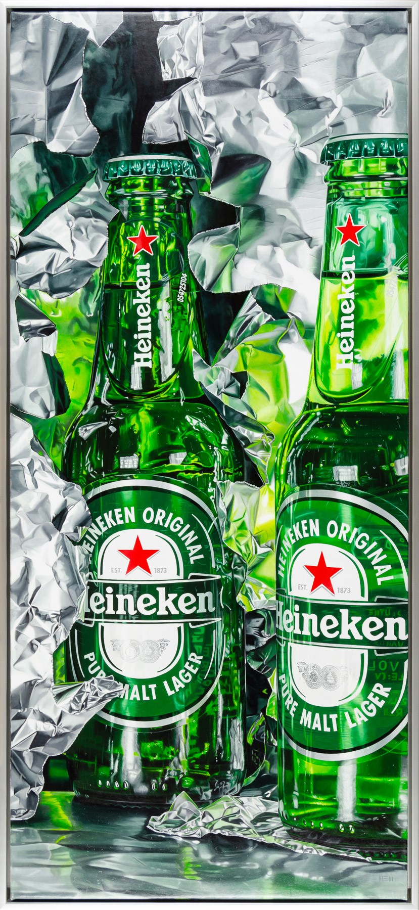 Two bottles of Heineken beer sitting on top of tin foil.