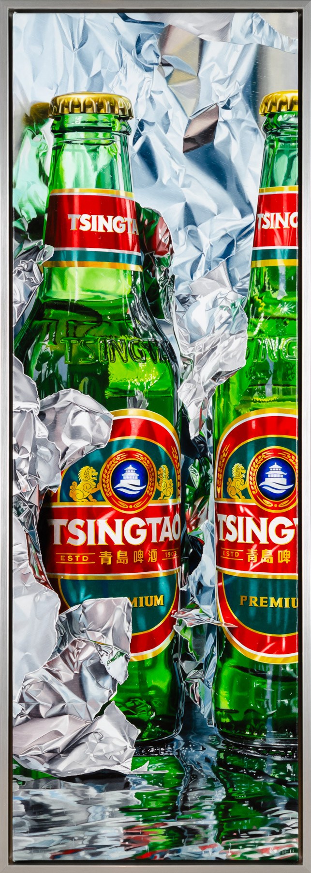 Two bottles of Tsingtao beer sitting on top of tin foil.