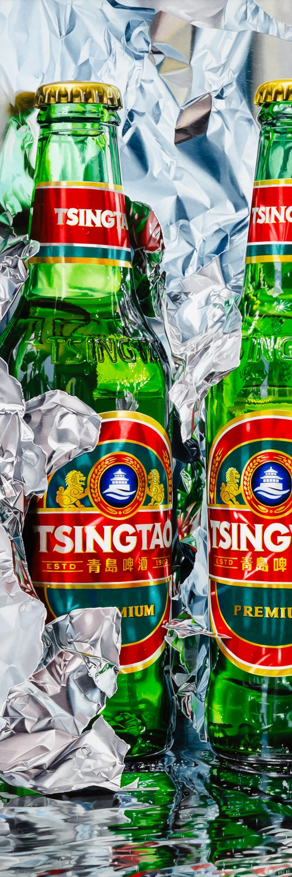Two bottles of Tsingtao beer sitting on top of tin foil.