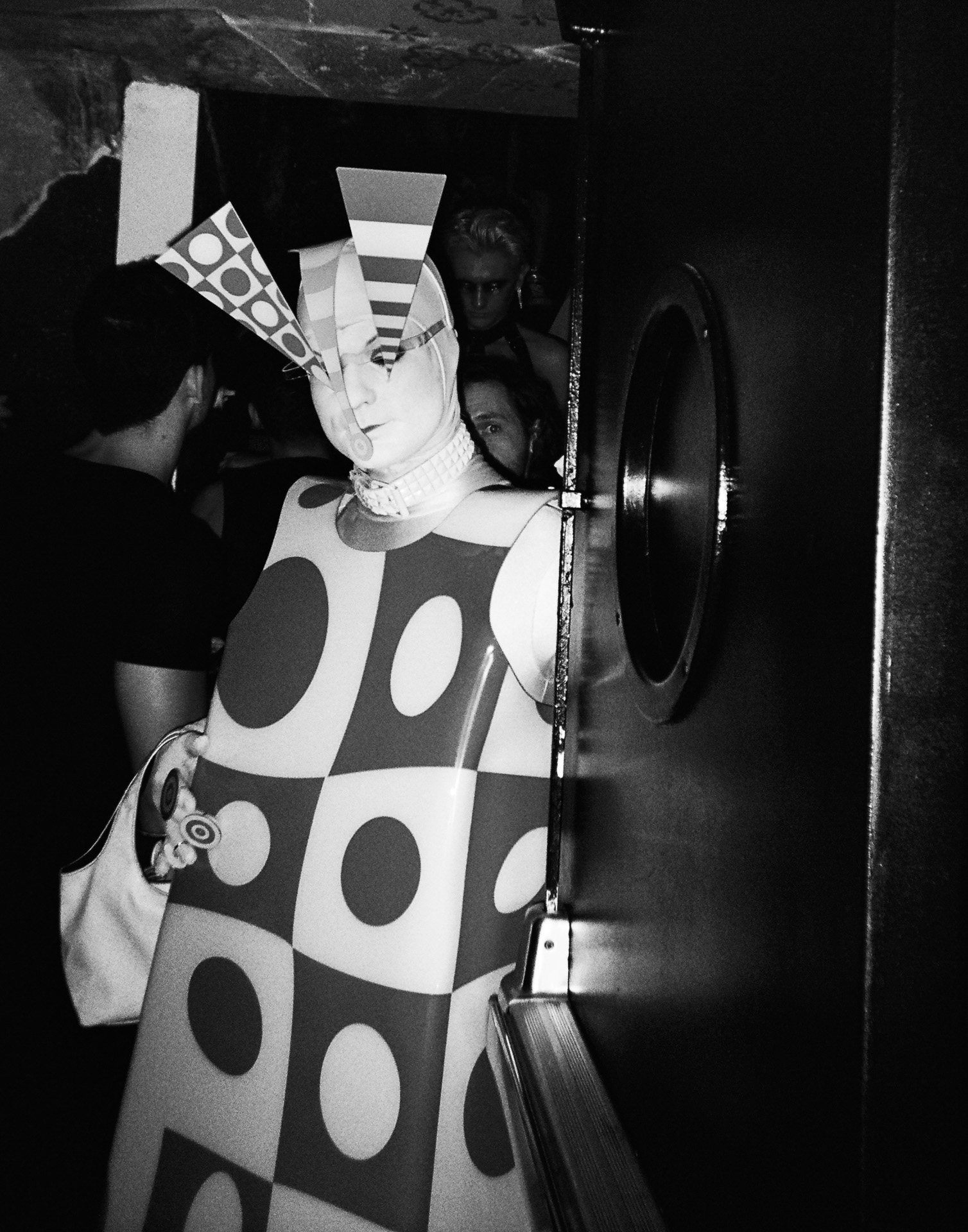 A woman in a costume standing in front of a door.