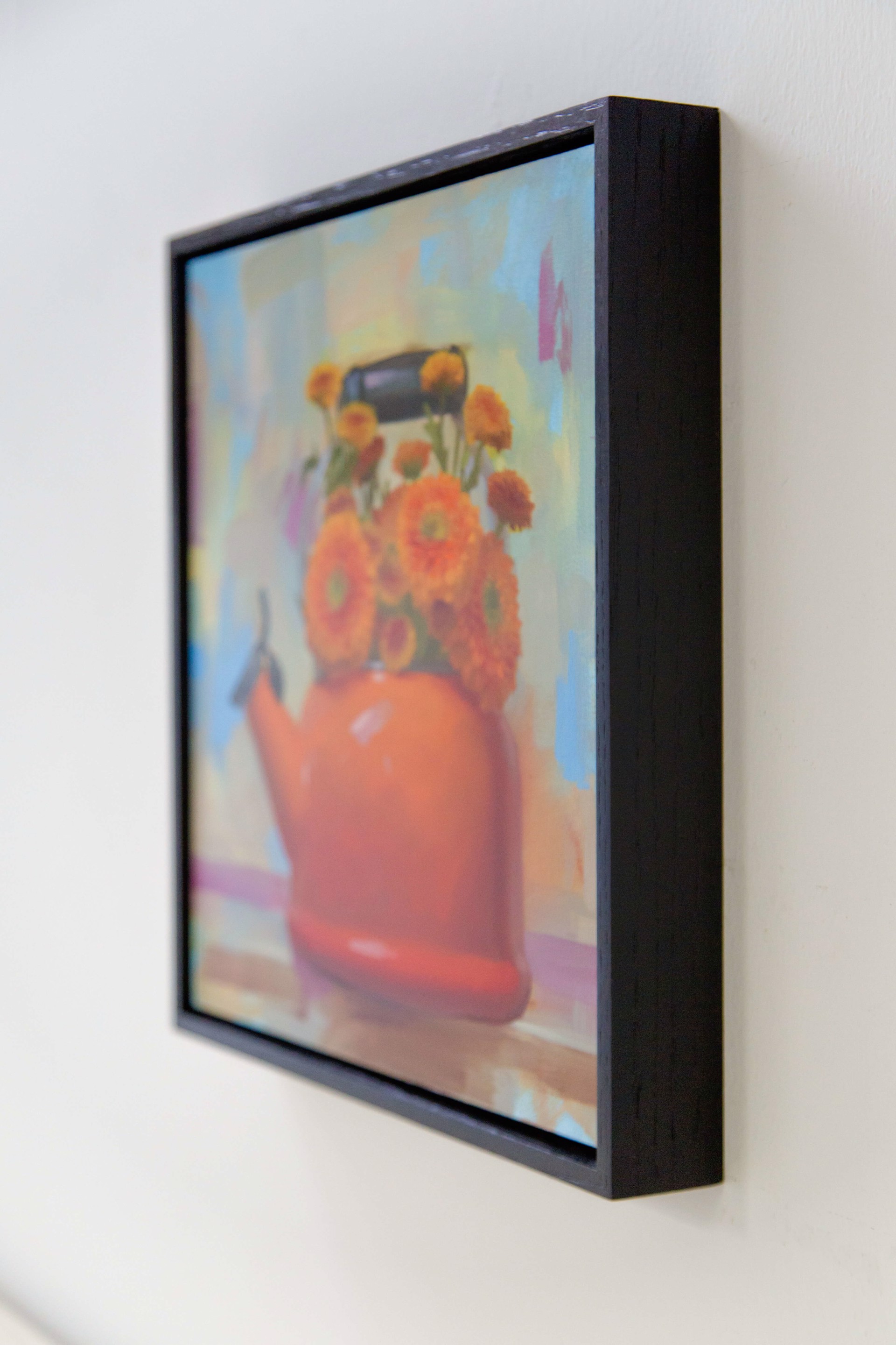 A painting of a red teapot with orange flowers in it.