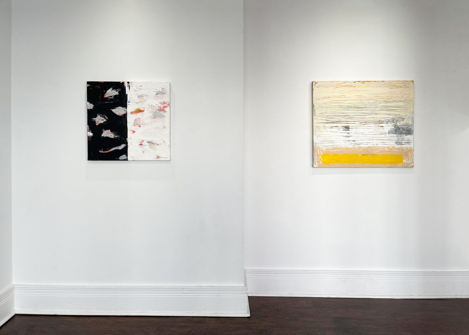 A stark abstract painting split by a vertical line, featuring bold black and white textures with splashes of red.