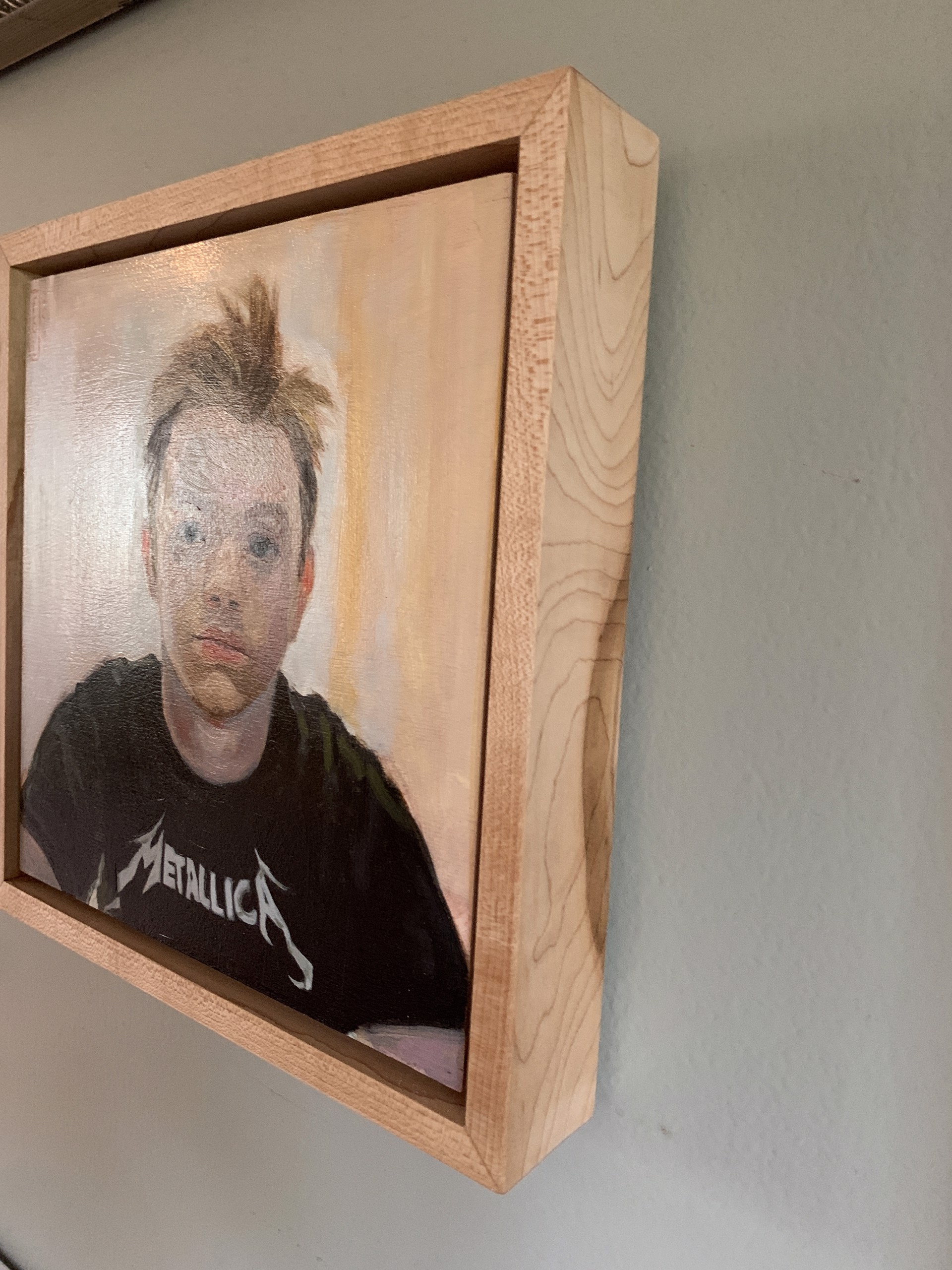 A painting of a young man wearing a Metallica shirt.