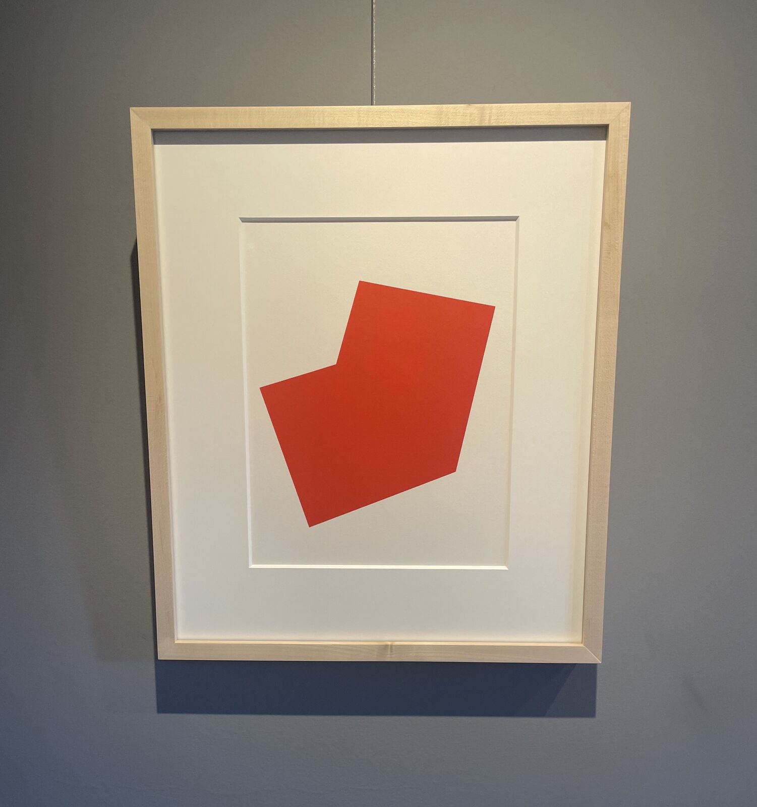A bold red L-shaped geometric form on a plain white background.