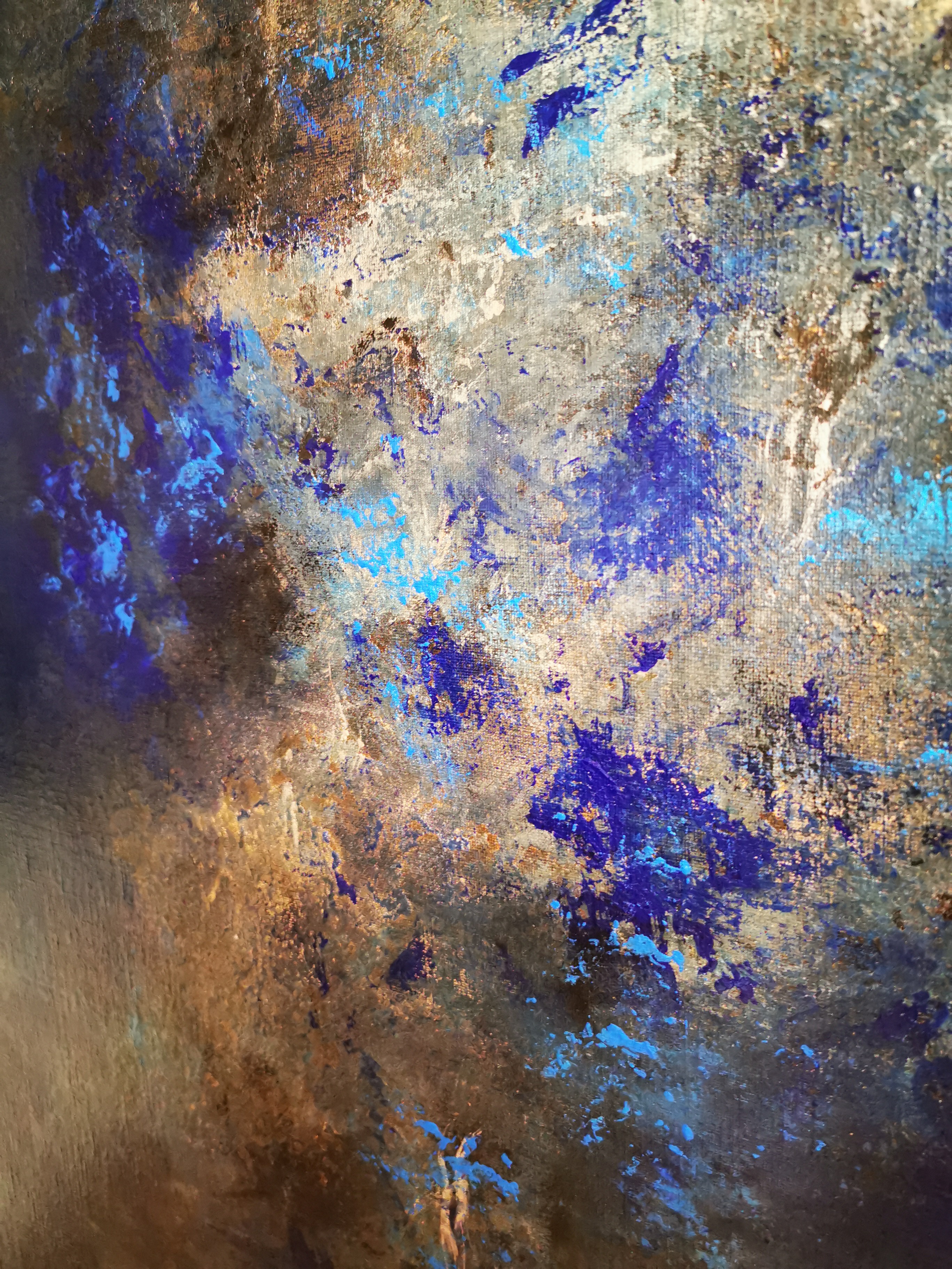 A close up of a blue and gold painting on a wall.