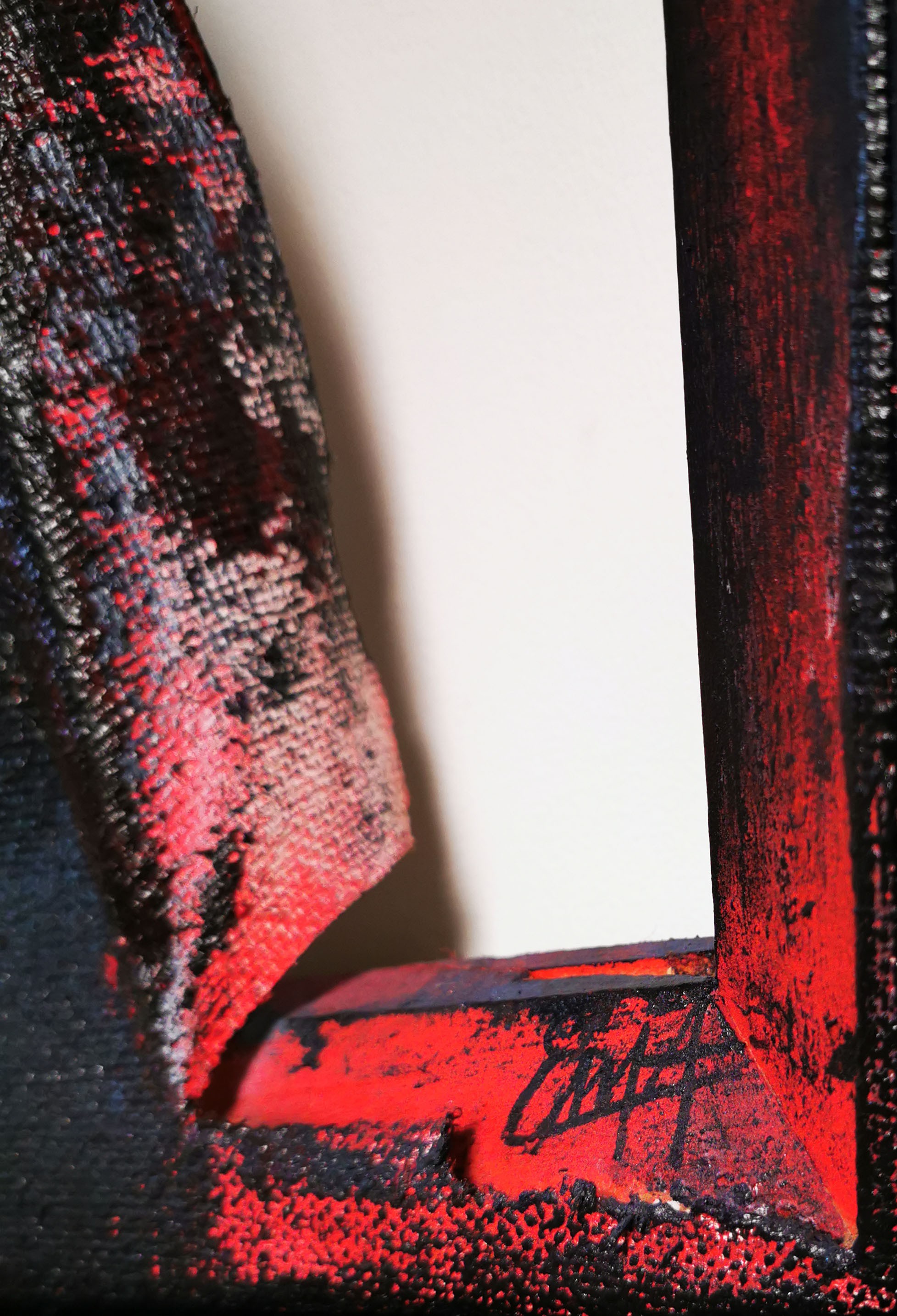 A close up of a red and black painting on a wall.