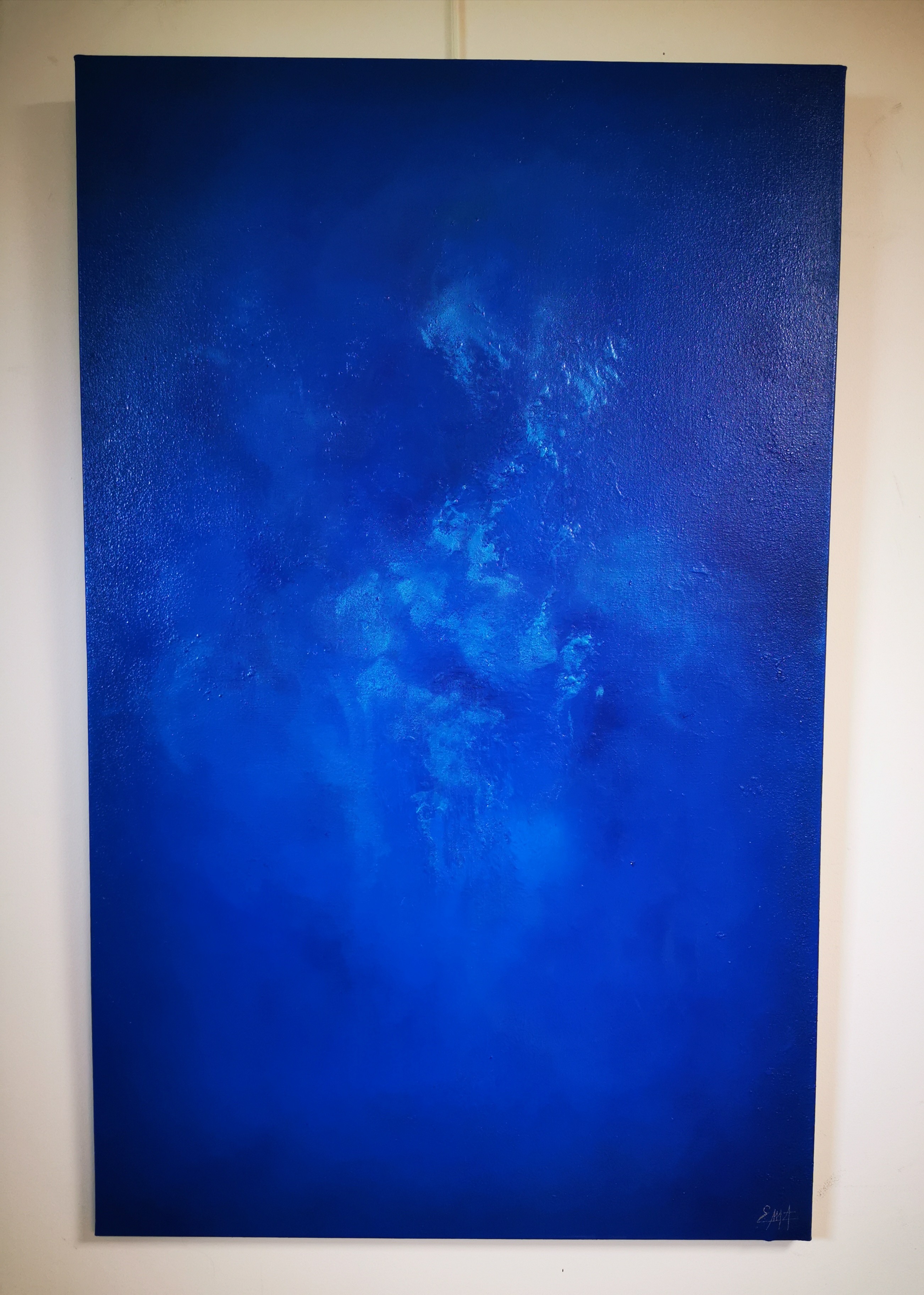 A large blue painting hanging on a wall.