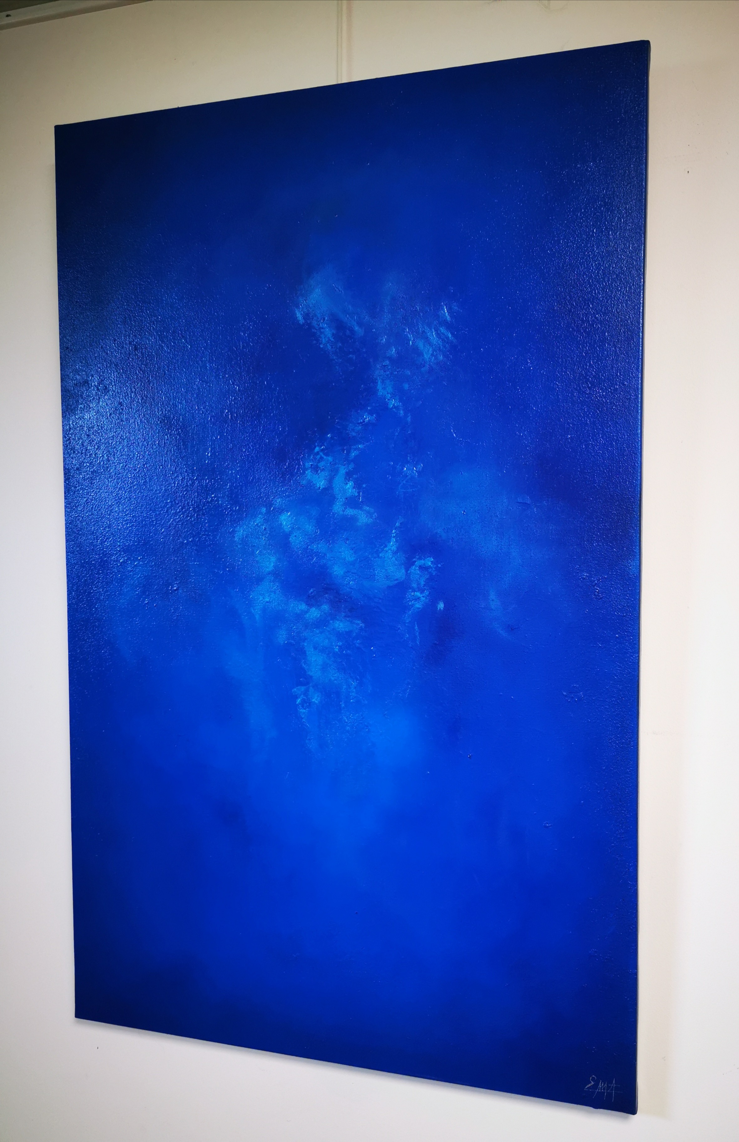 A large blue painting hanging on a wall.